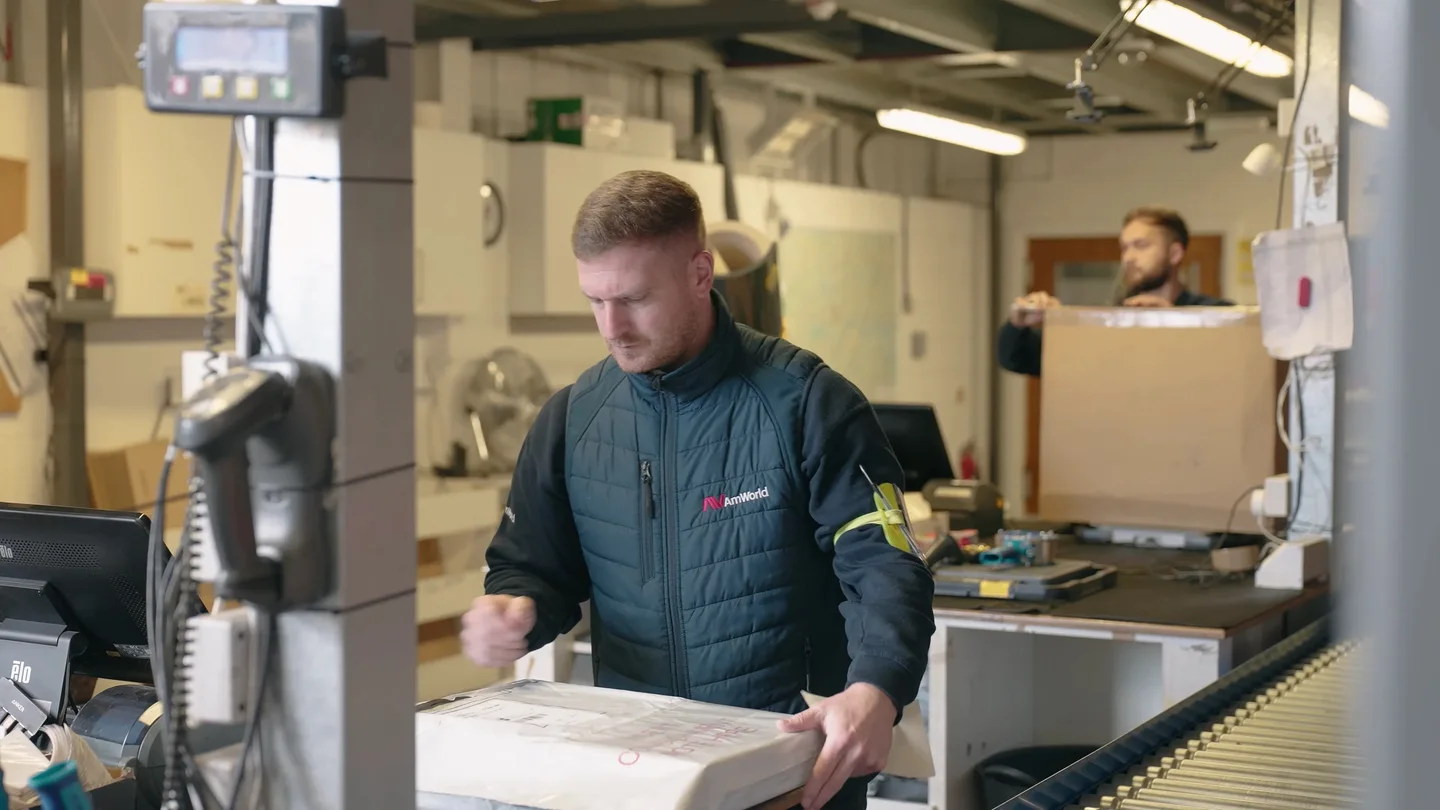 AMWORLD team member handling a parcel in the warehouse