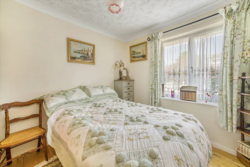 Bedroom with a floral bedspread and garden-facing window in Cavendish