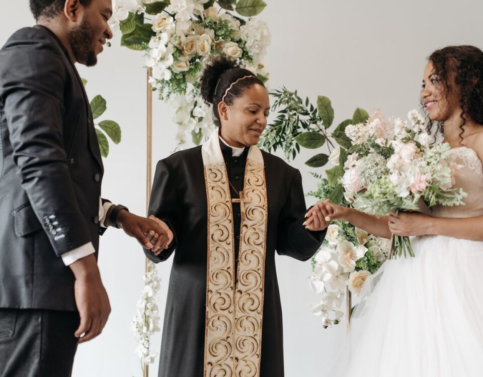 Elegant wedding ceremony showcasing a bride, groom, and pastor exchanging vows in a floral setting