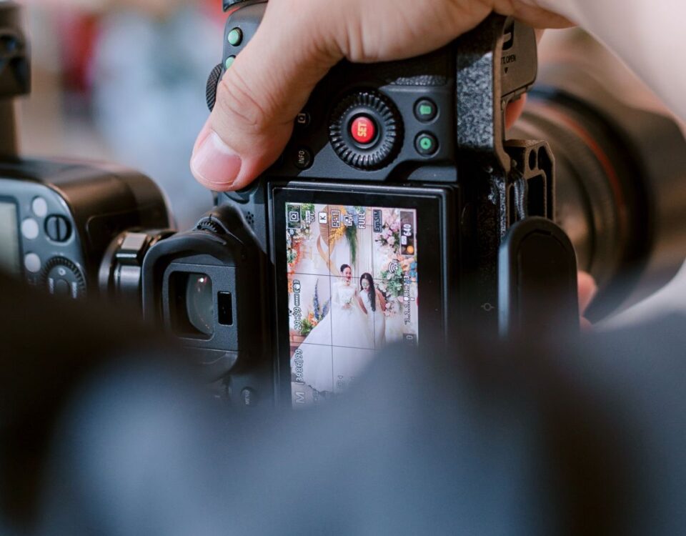 Behind-the-scenes shot of a photographer taking wedding photos indoors