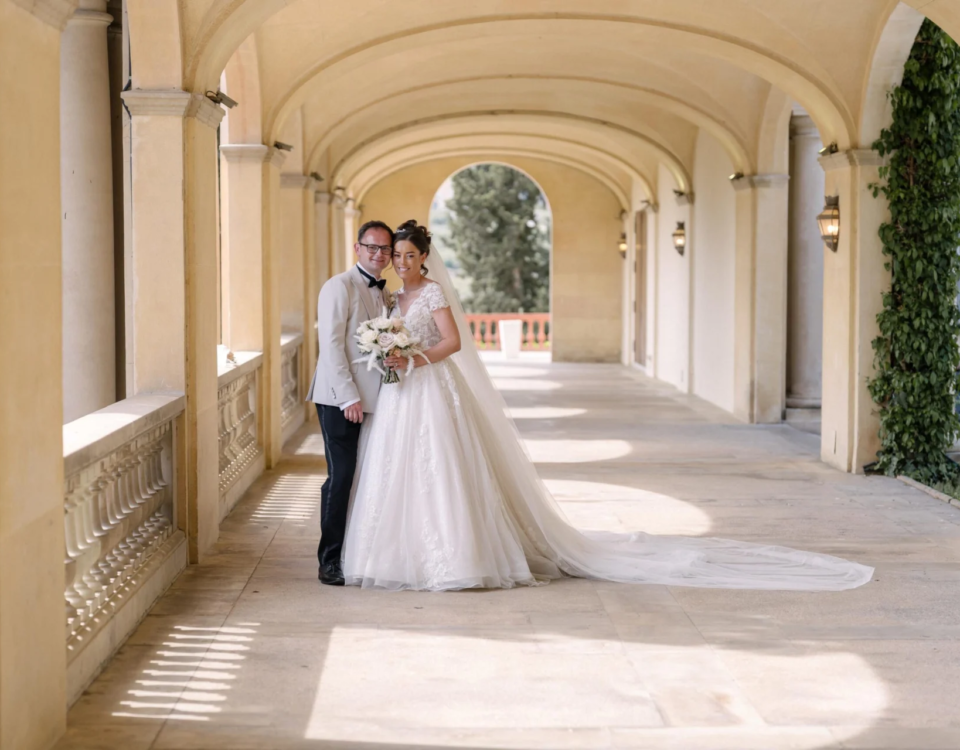 Wedding couple beneath a grand arched colonnade