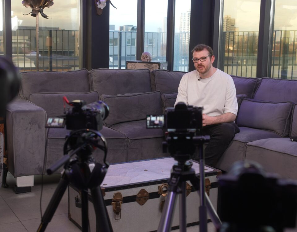 Two cameras recording a seated speaker in an interview setup