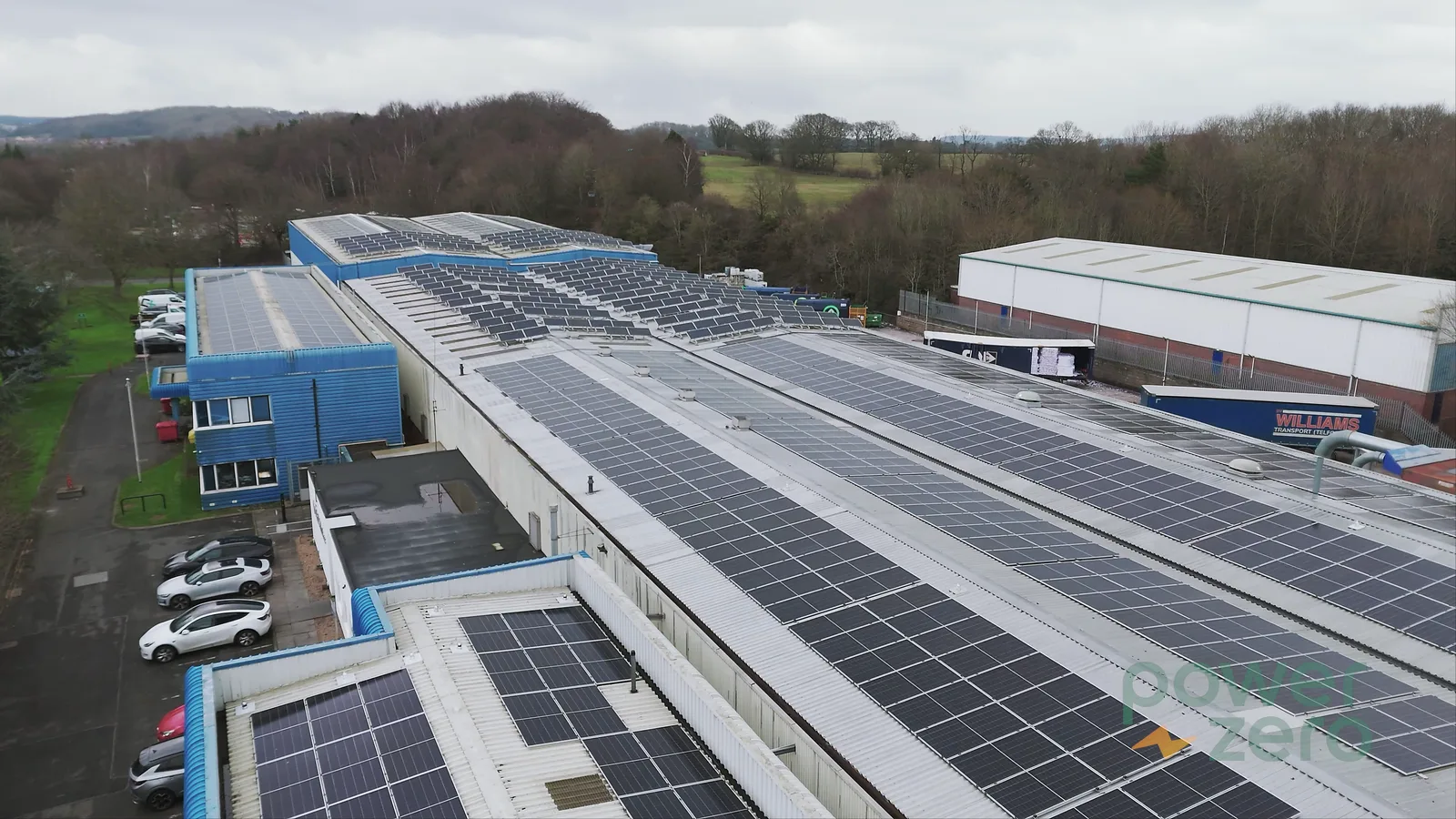 Aerial film frame showing a commercial rooftop solar installation