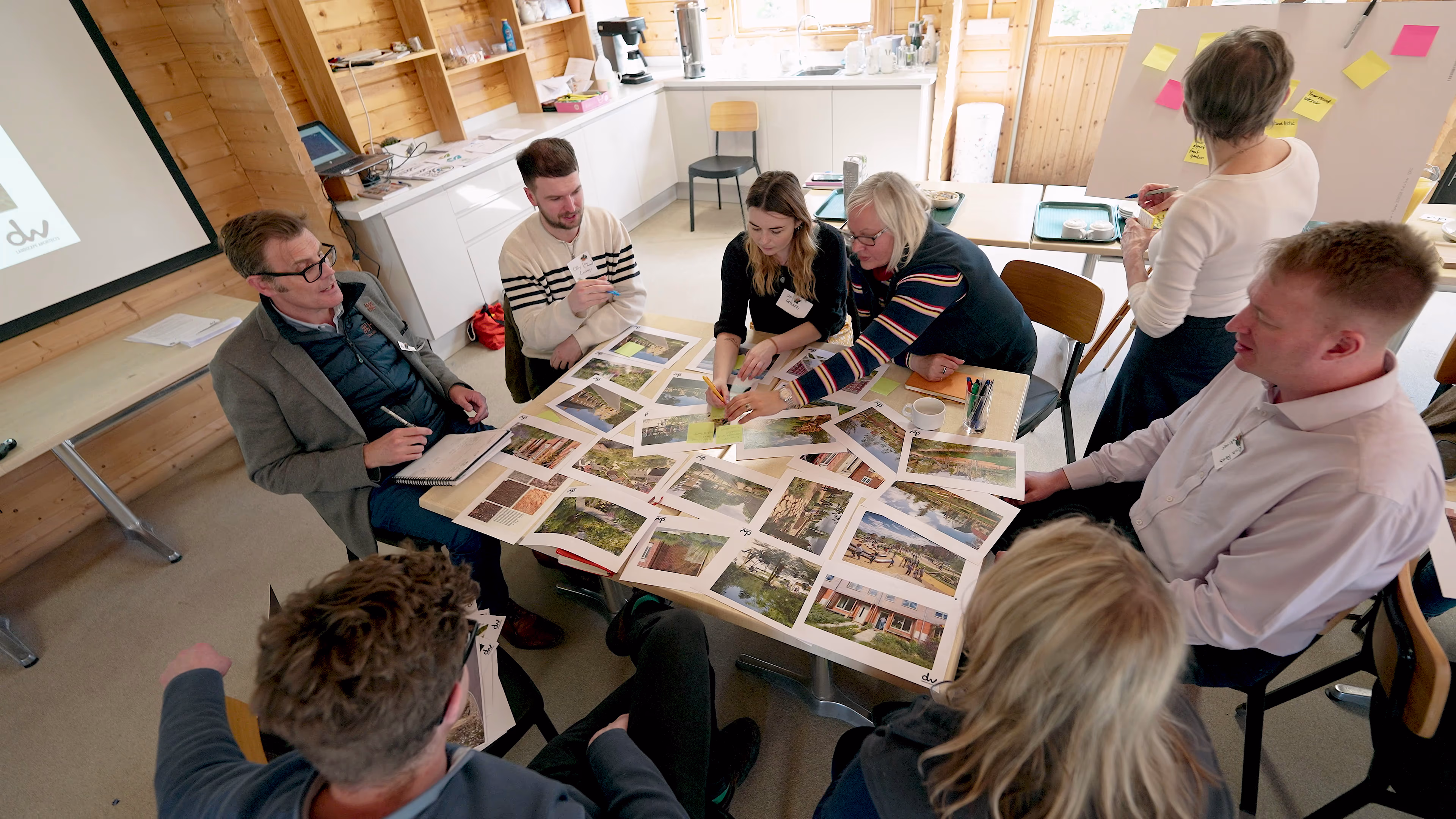 Workshop participants discussing printed landscape images around a table