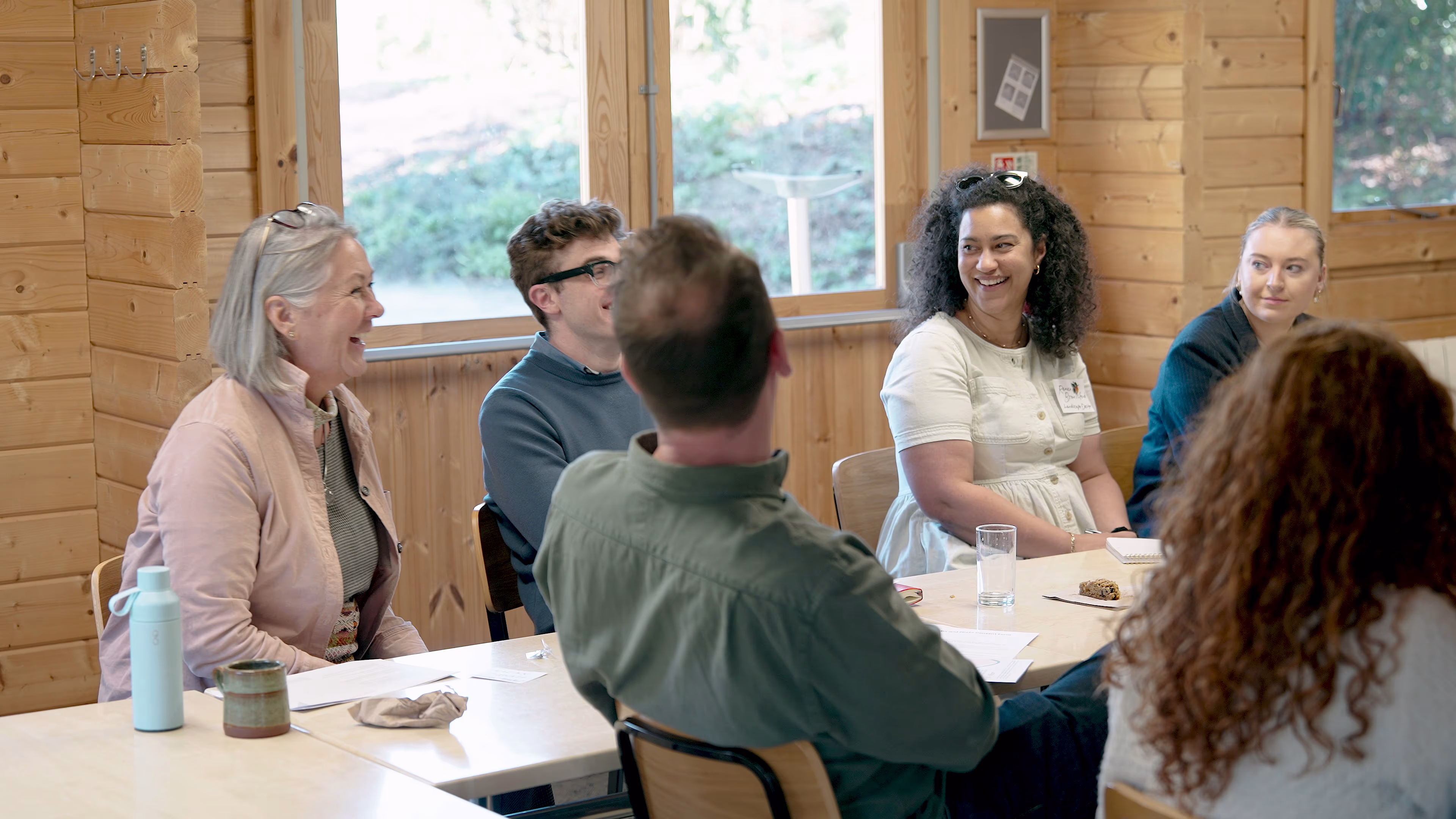 Attendees listening and talking around a workshop table