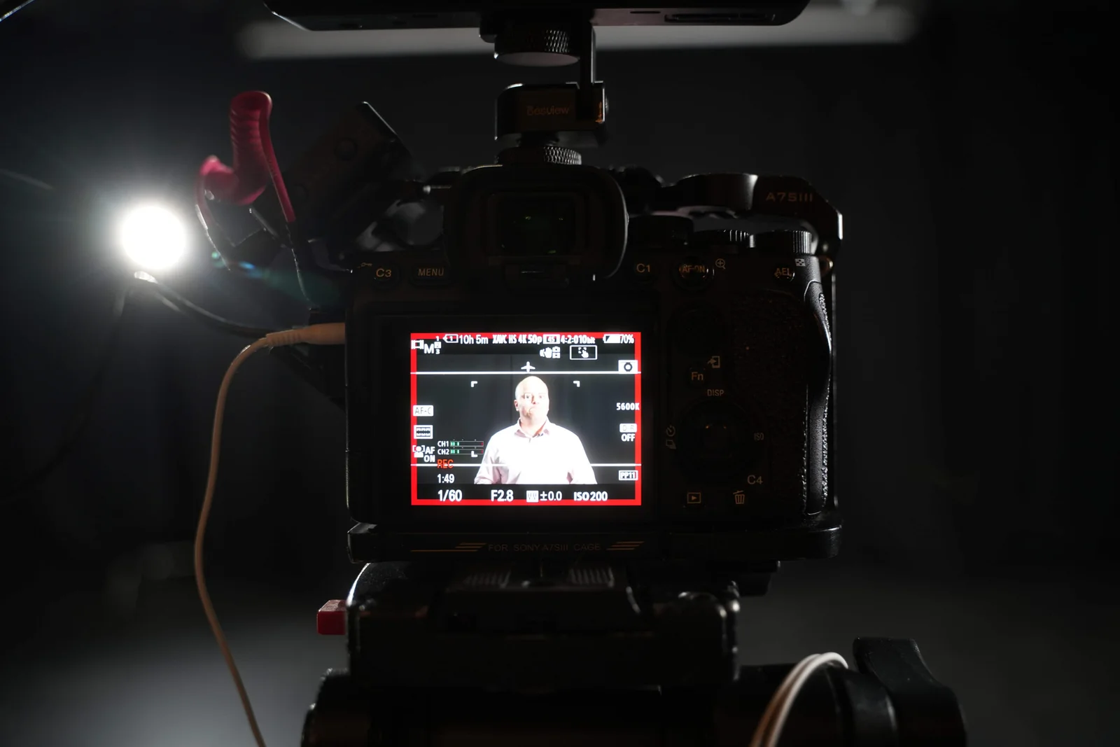 Cinema camera monitor showing a seated interview subject