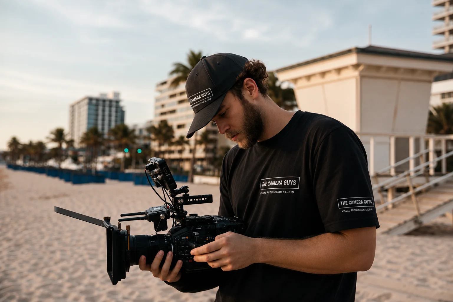 Videographer checking a cinema camera rig beside the waterfront