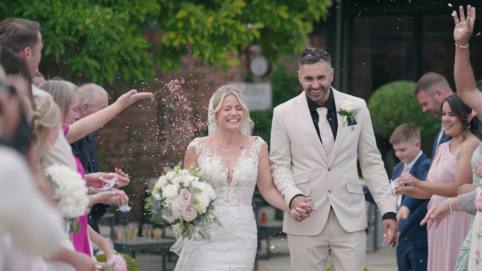Jake and Lisa walking through confetti after their wedding ceremony
