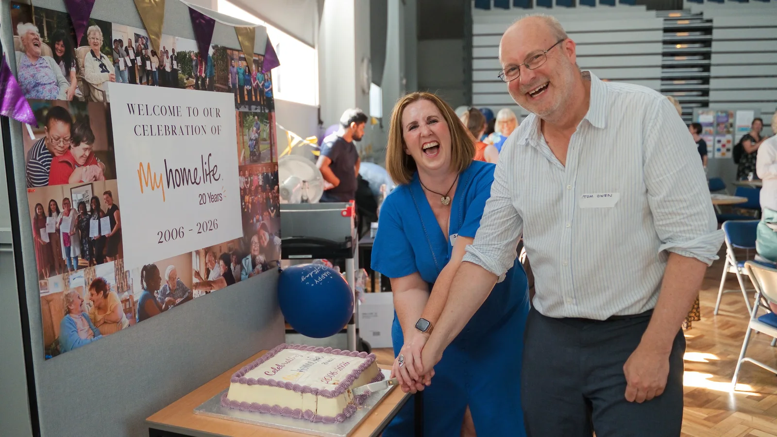 Guests cutting an anniversary cake at the My Home Life event