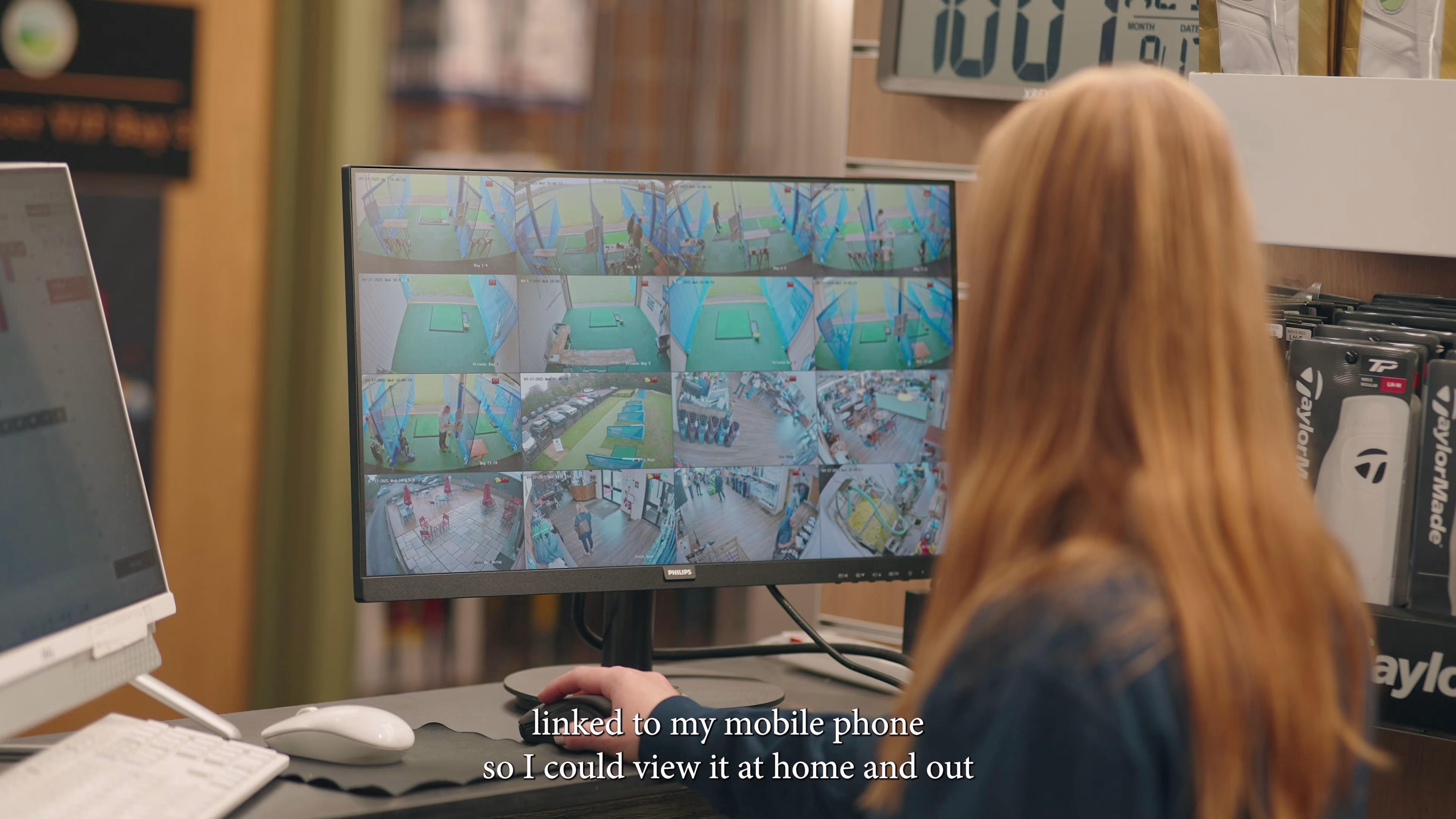 Staff member viewing a multi-camera monitor behind the counter