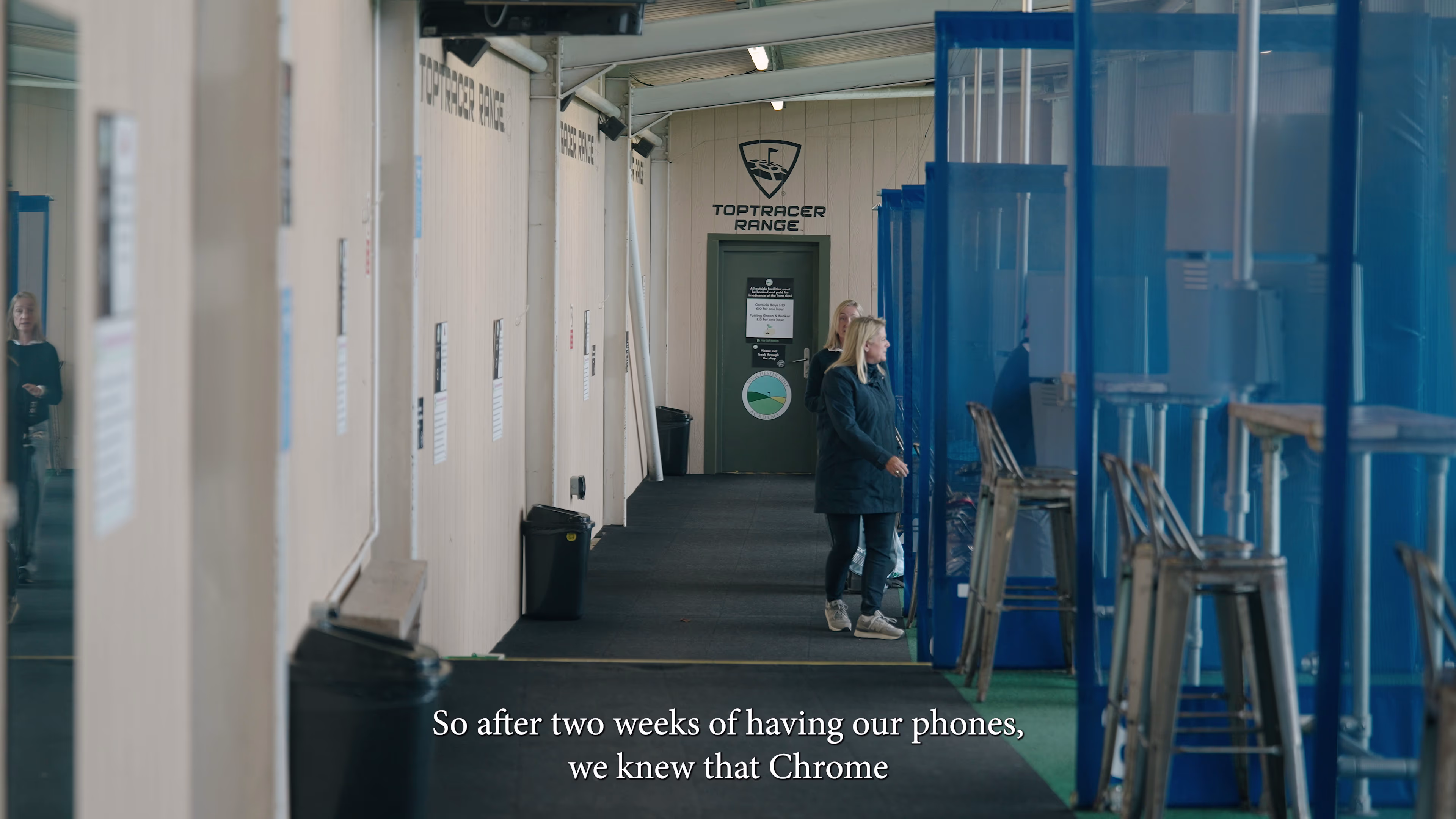 Staff member walking beside the covered golf driving bays