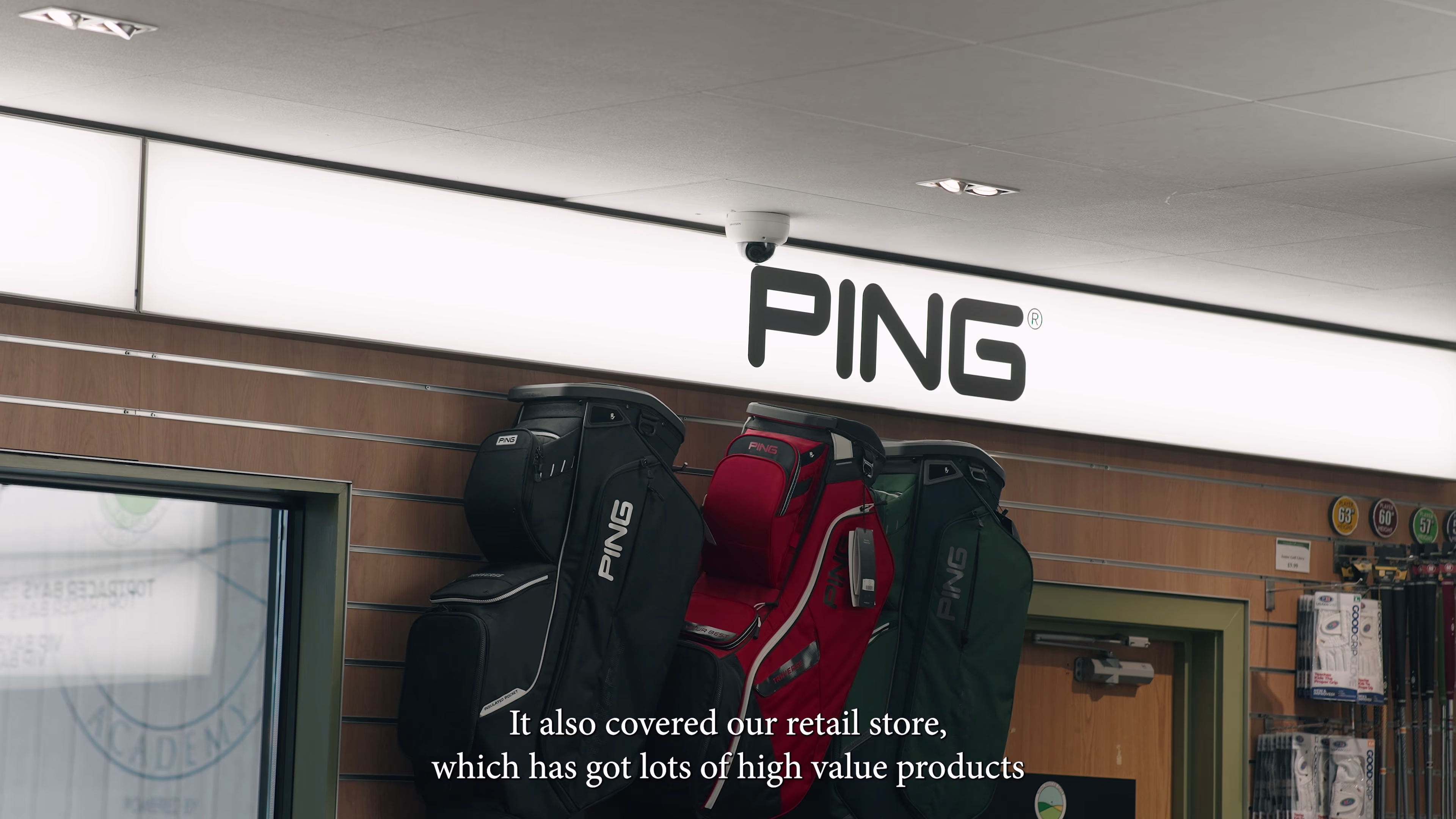 Golf bags displayed beneath PING signage in the academy shop