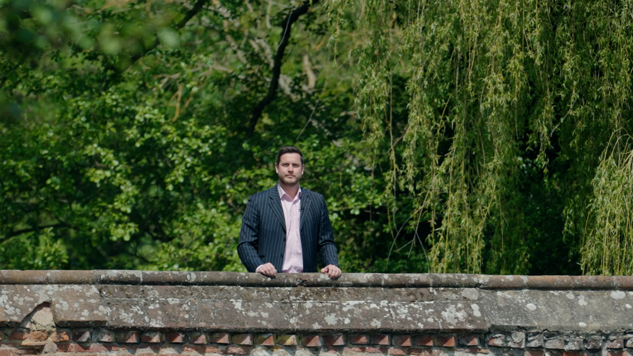 Edd presenting to camera on a bridge in Hadleigh — film still