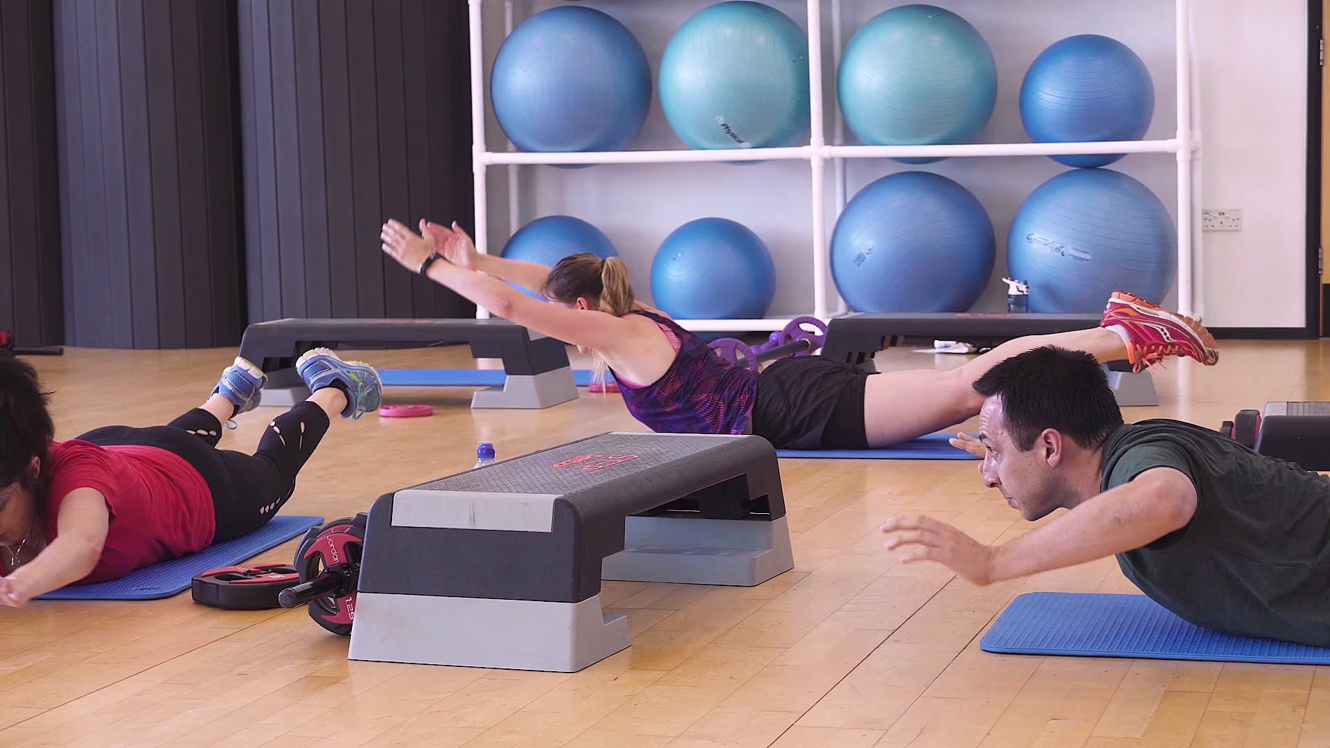 Fitness class performing floor exercises with step platforms