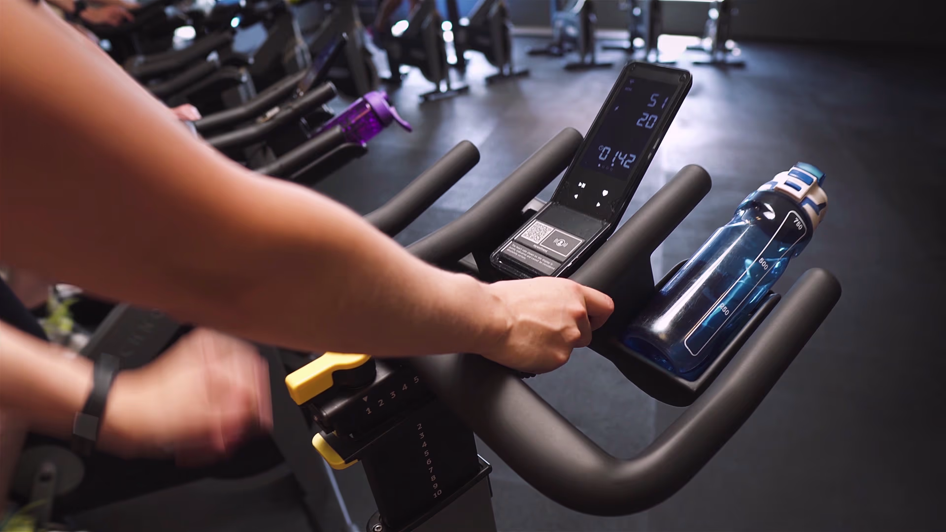 Close-up of handlebars during an indoor cycling class