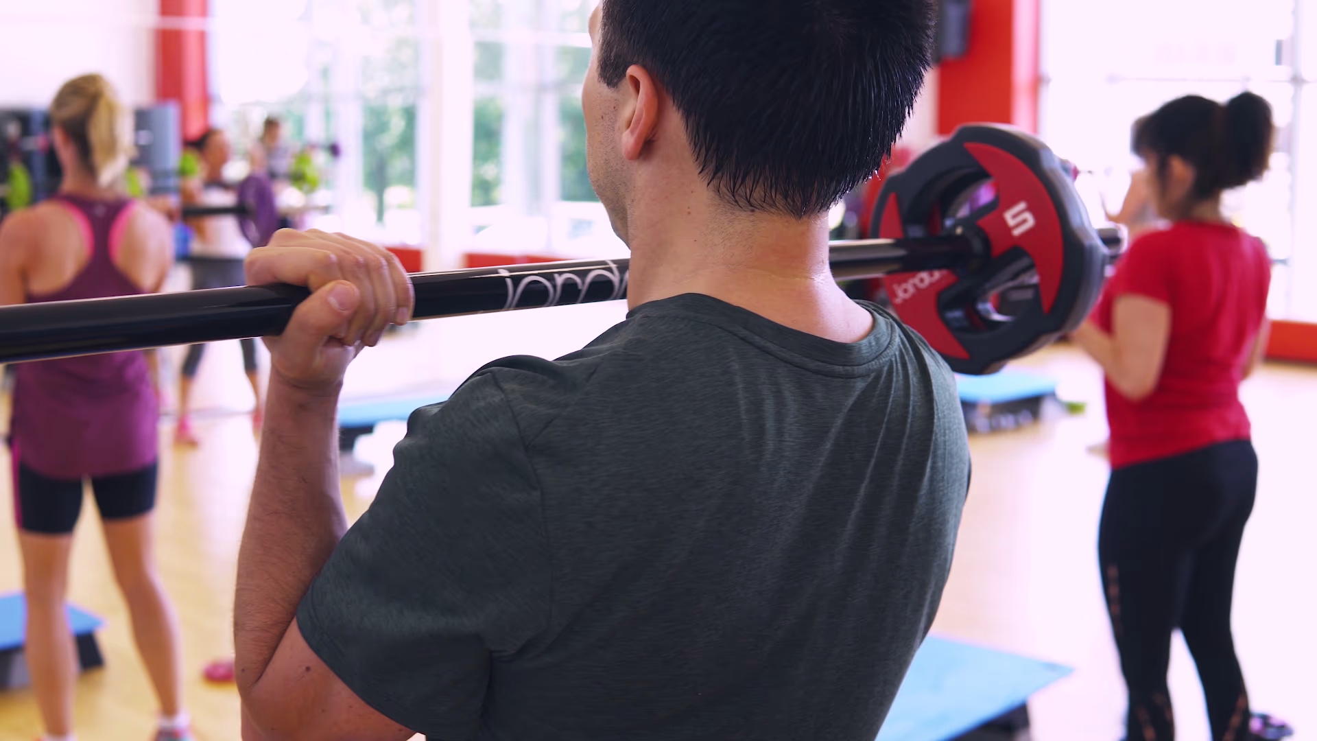 Participant lifting a barbell during an Essex Sport pump class