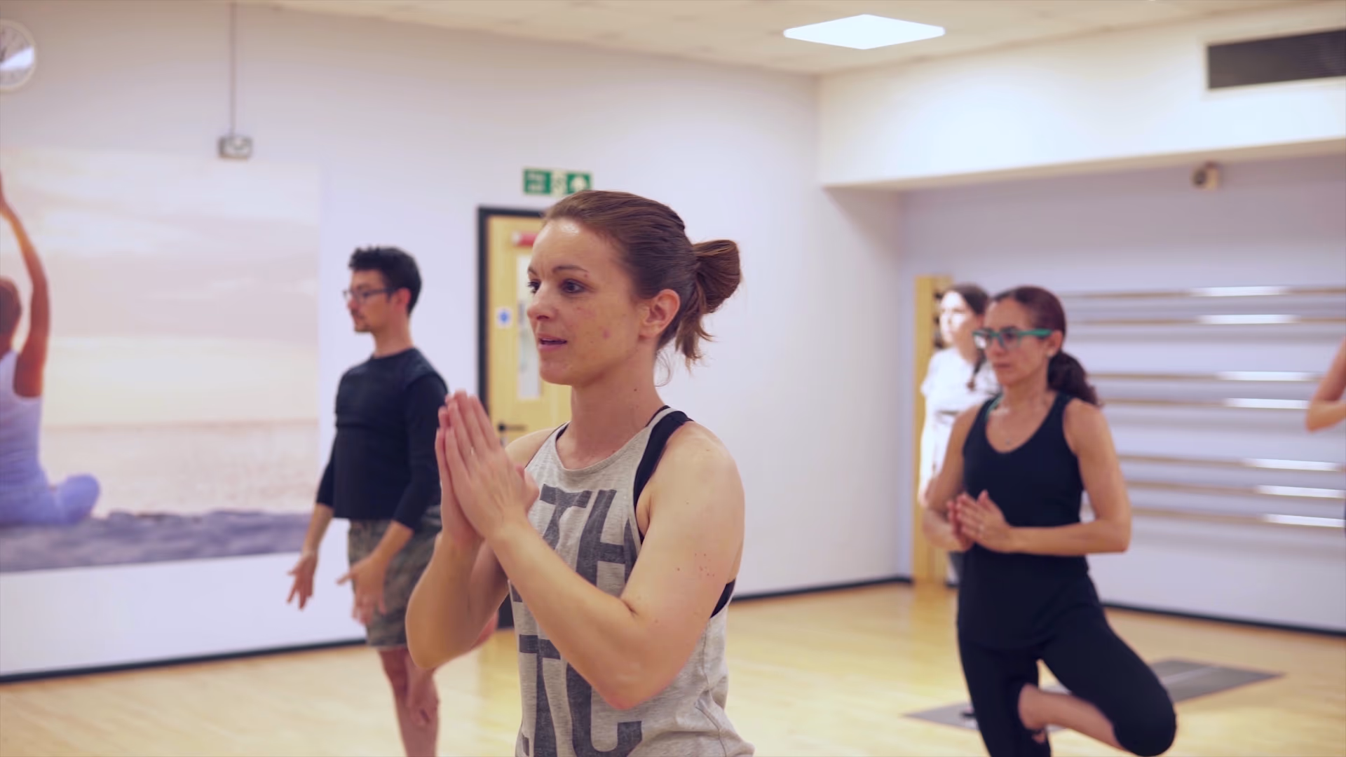 Participants holding a balance pose during yoga