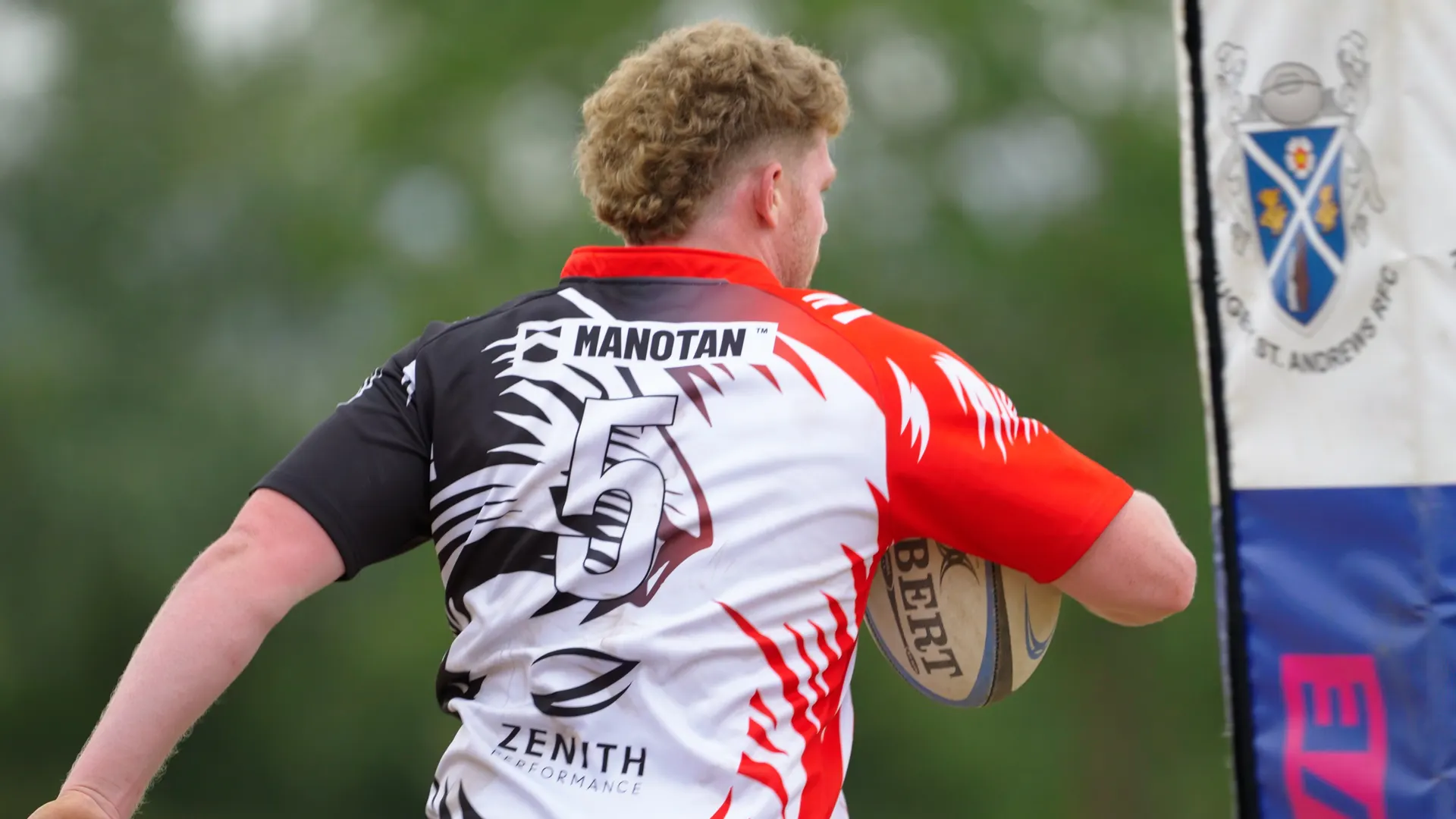 MANOTAN sponsor branding on a TR7 player’s shirt beside the Rugby St Andrews post