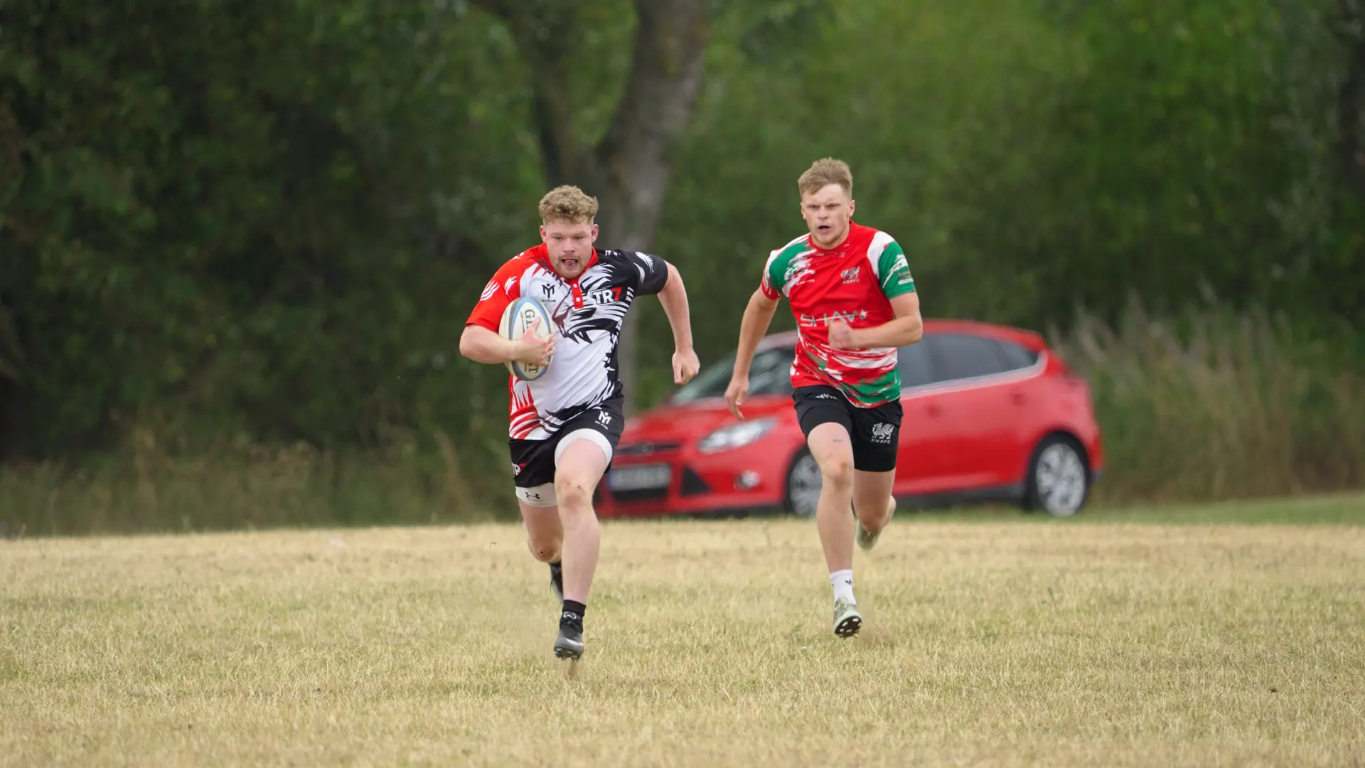 TR7 ball carrier running clear with an opponent in pursuit
