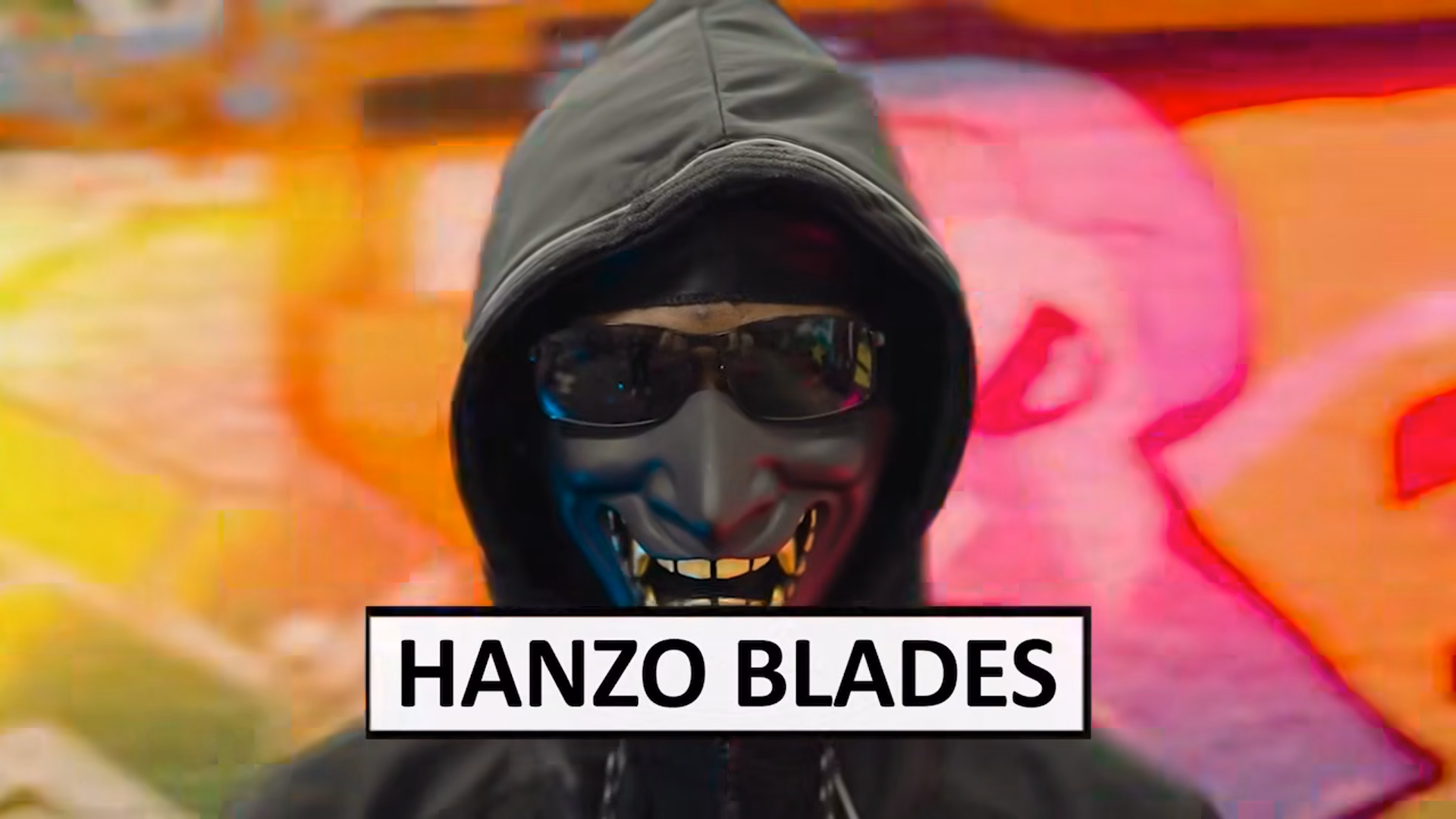 Masked Hanzo Blades performer lit against graffiti in the London tunnel