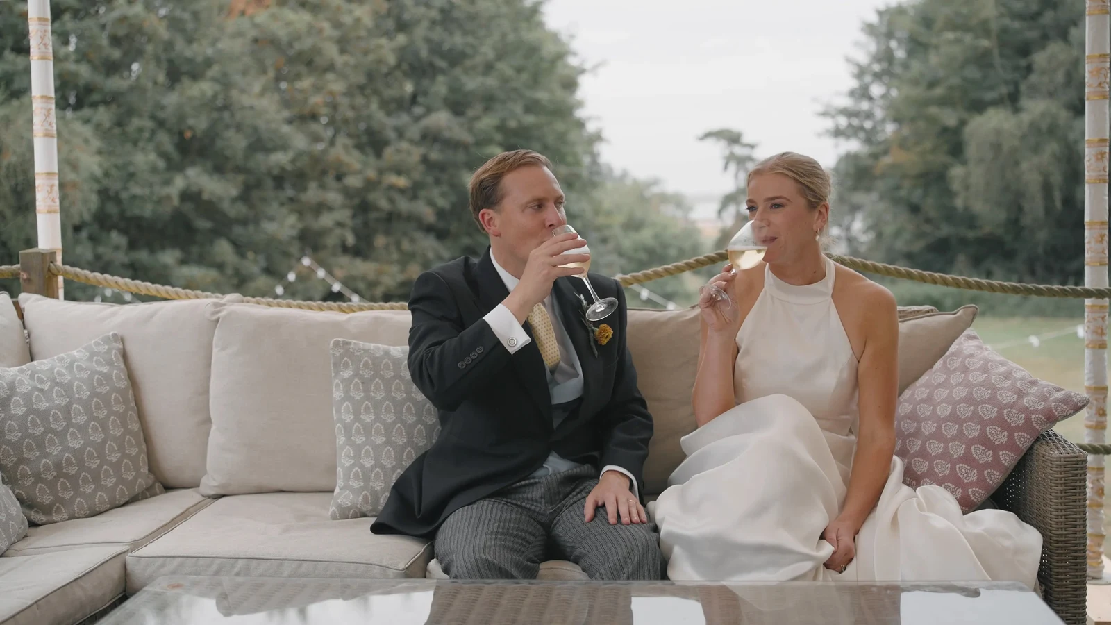 Film still: Harriet and Luke seated together during the reception