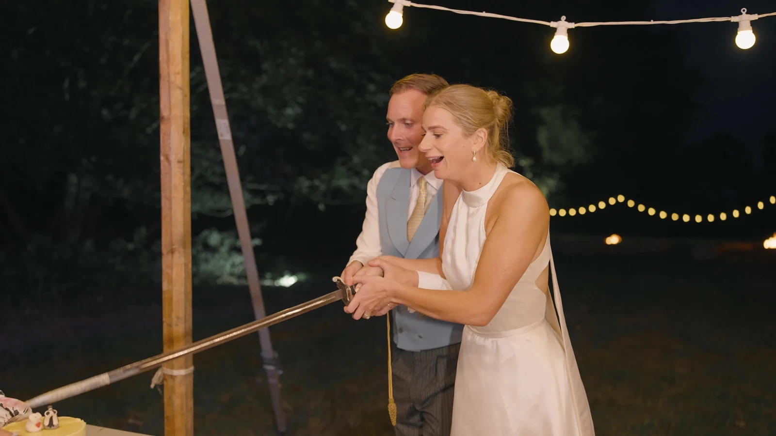 Film still: Harriet and Luke dancing beneath the evening lights
