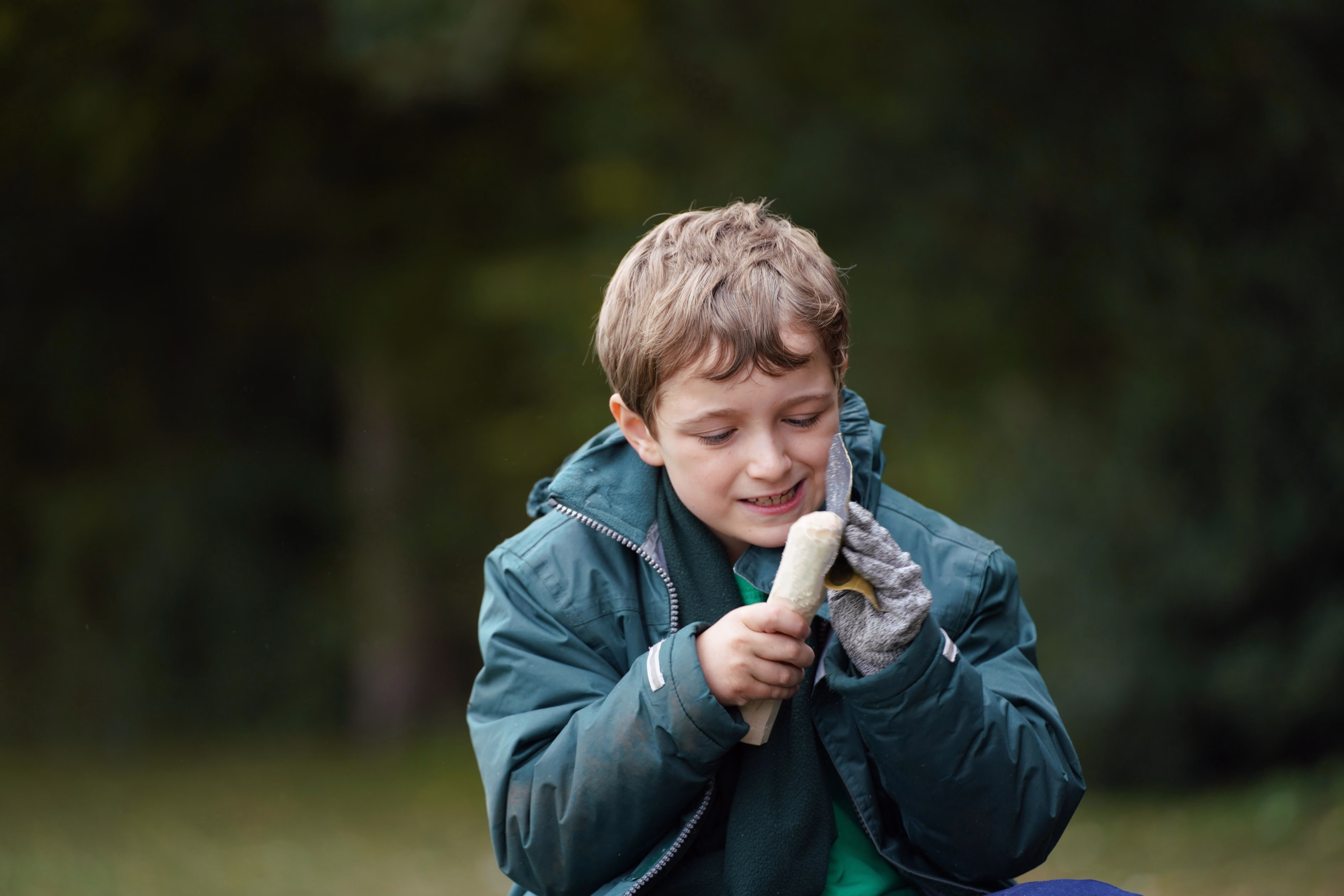 Child concentrating on a hands-on bushcraft task