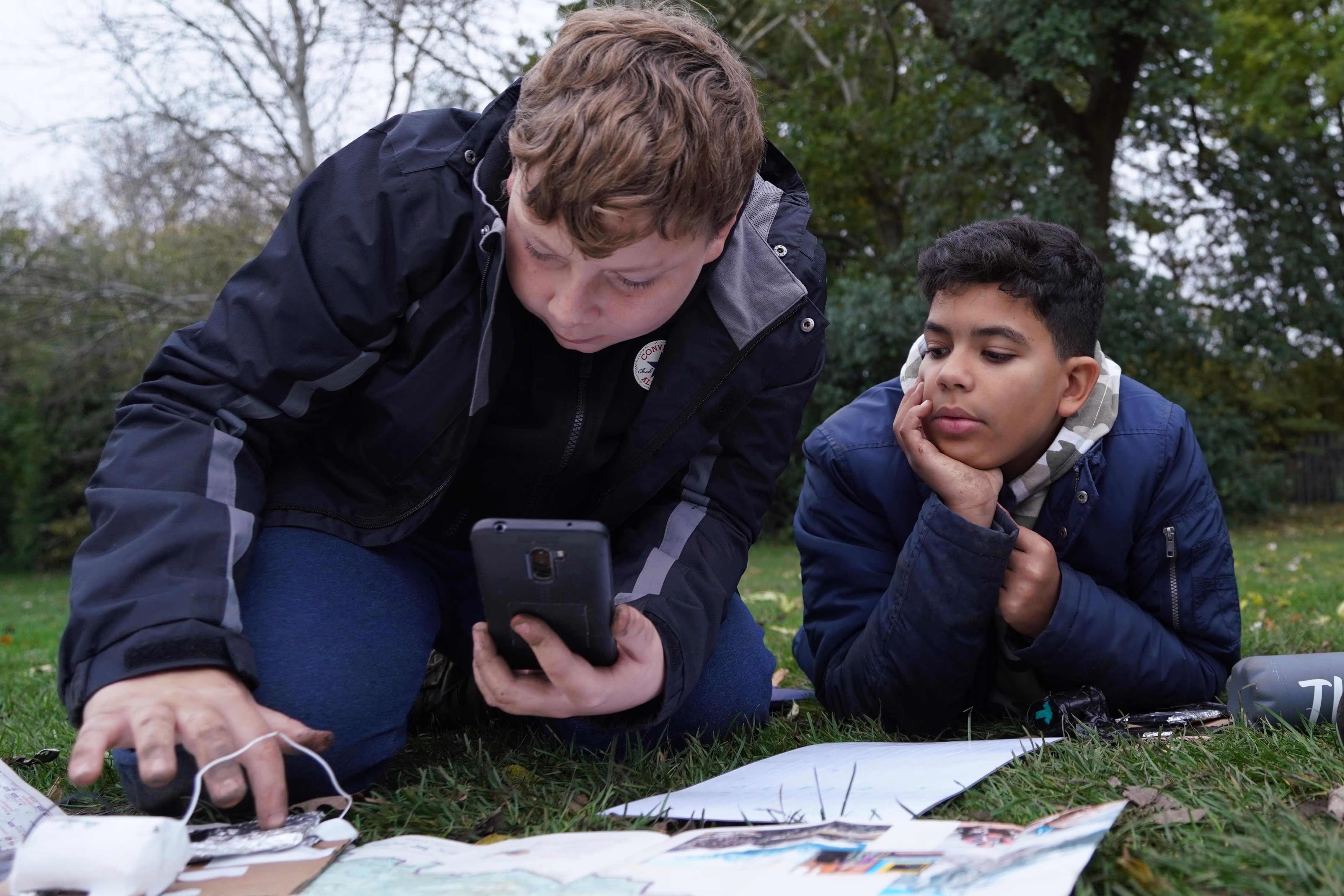 Instructor and child looking at activity materials outdoors