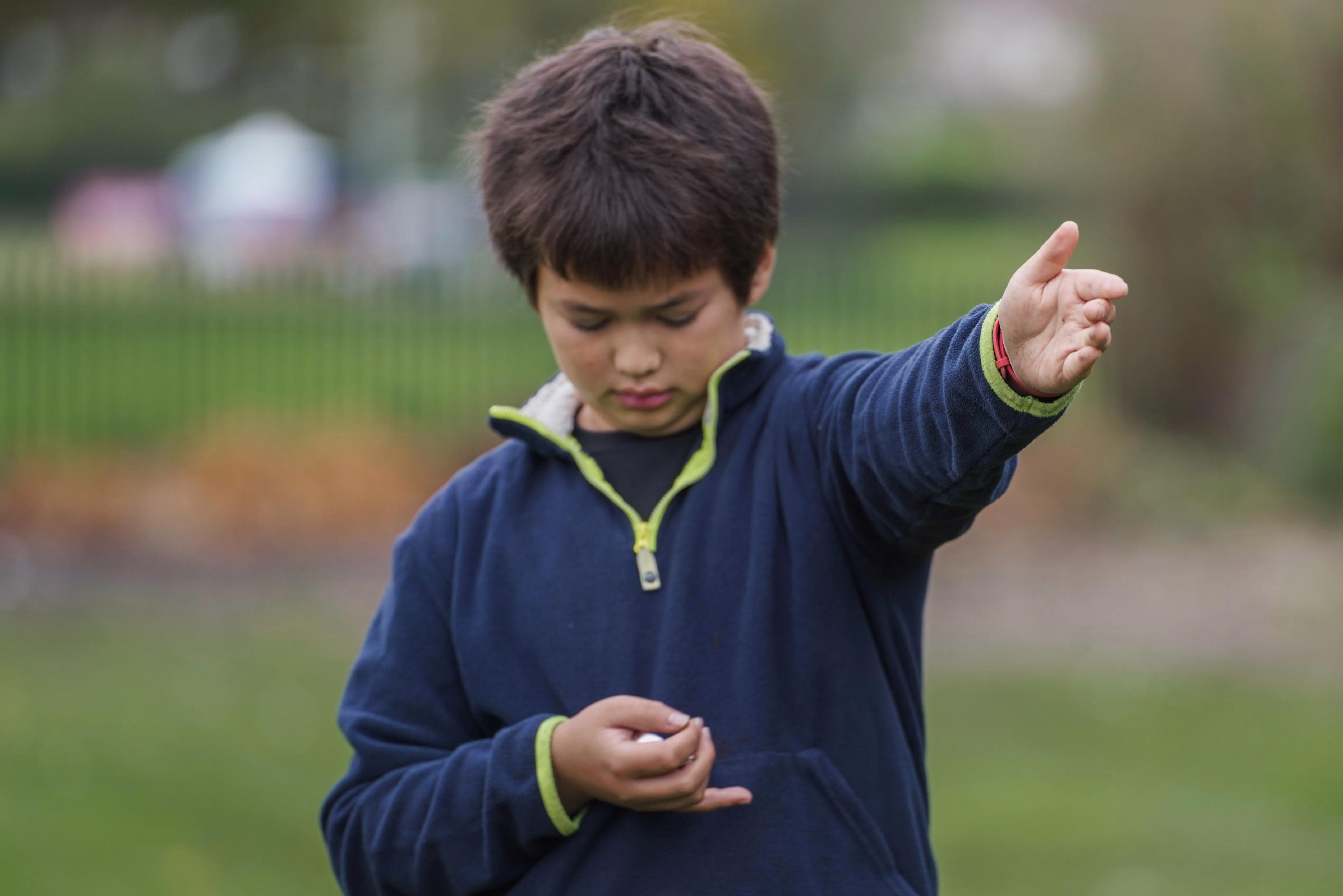 Child examining a small object during an outdoor workshop