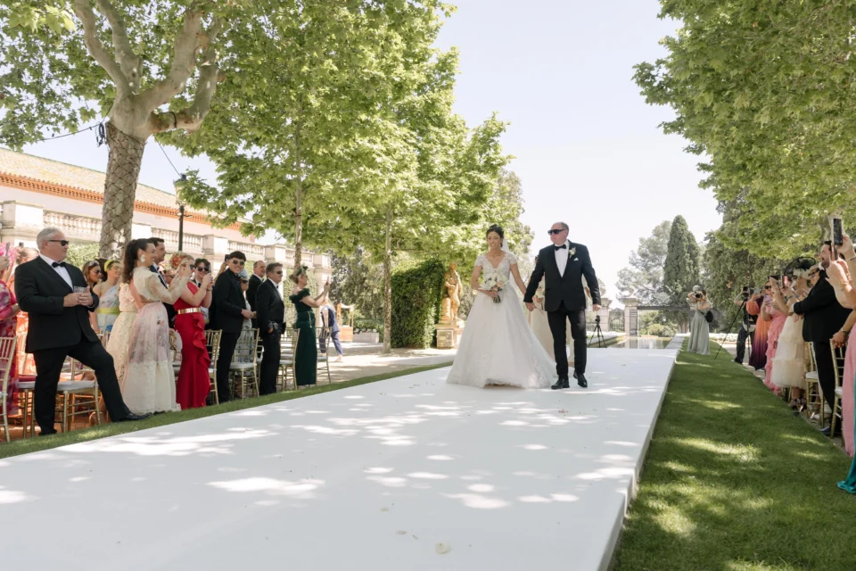Ellie walking down the outdoor wedding aisle