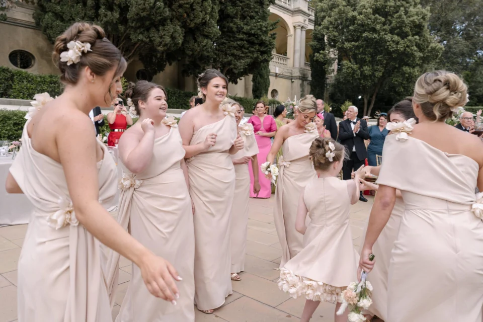 Bridesmaids laughing and singing together in the garden