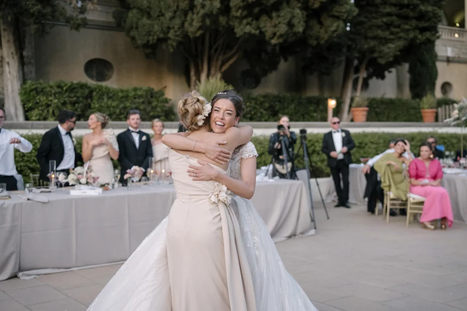 Ellie embracing a guest at the outdoor reception