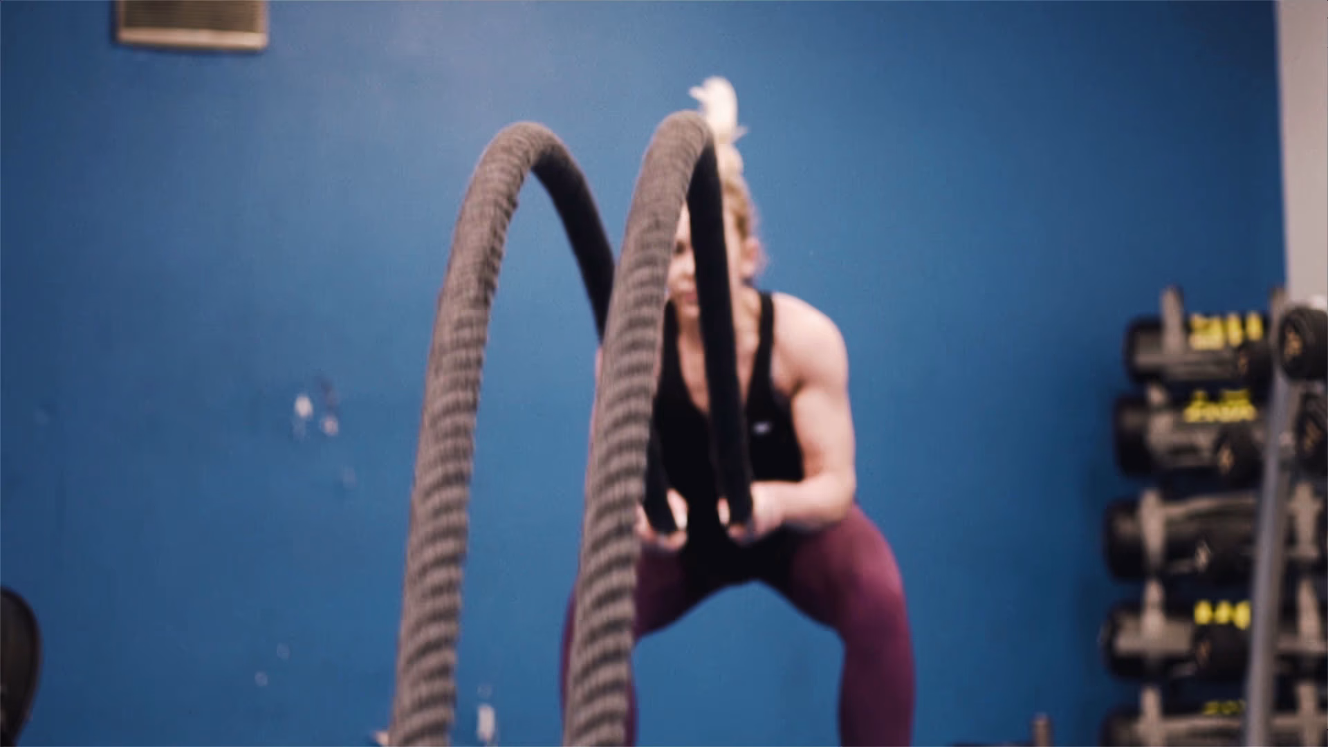 Gym client performing a battle rope exercise