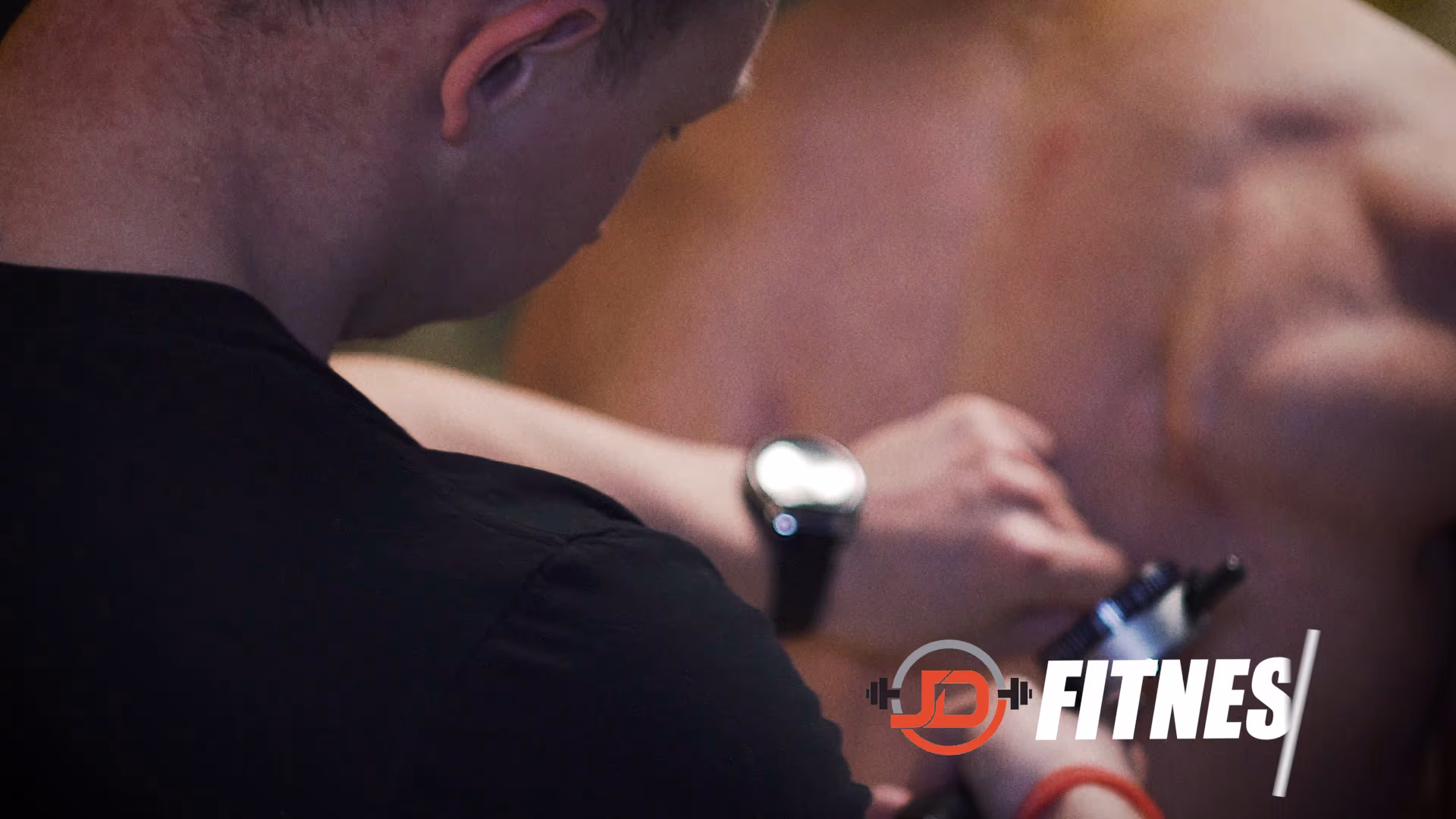 JD Fitness personal trainer coaching a client in the gym