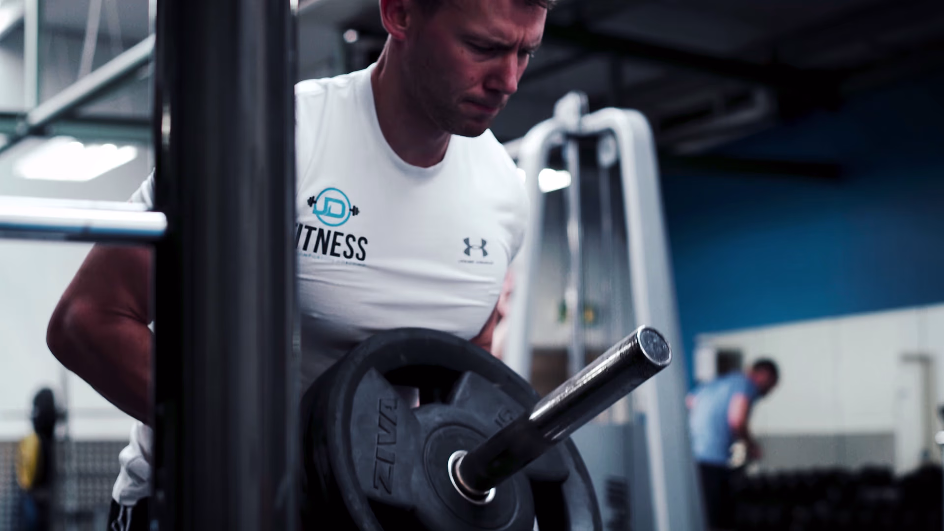 JD Fitness athlete preparing a weight plate exercise