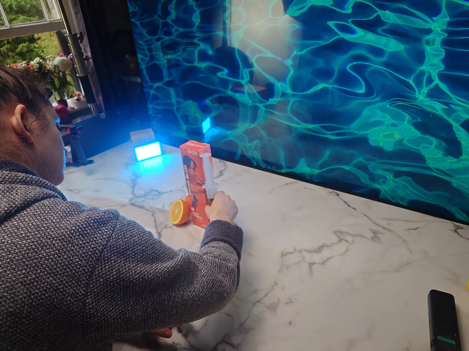 Arranging the Orange Splash box and orange slices in front of a pool-water backdrop
