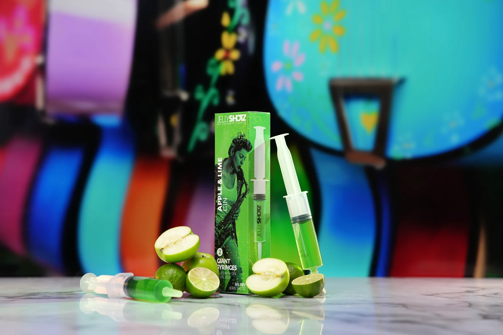 Jellyshotz Apple & Lime Gin — angled six-syringe pack with apples and limes