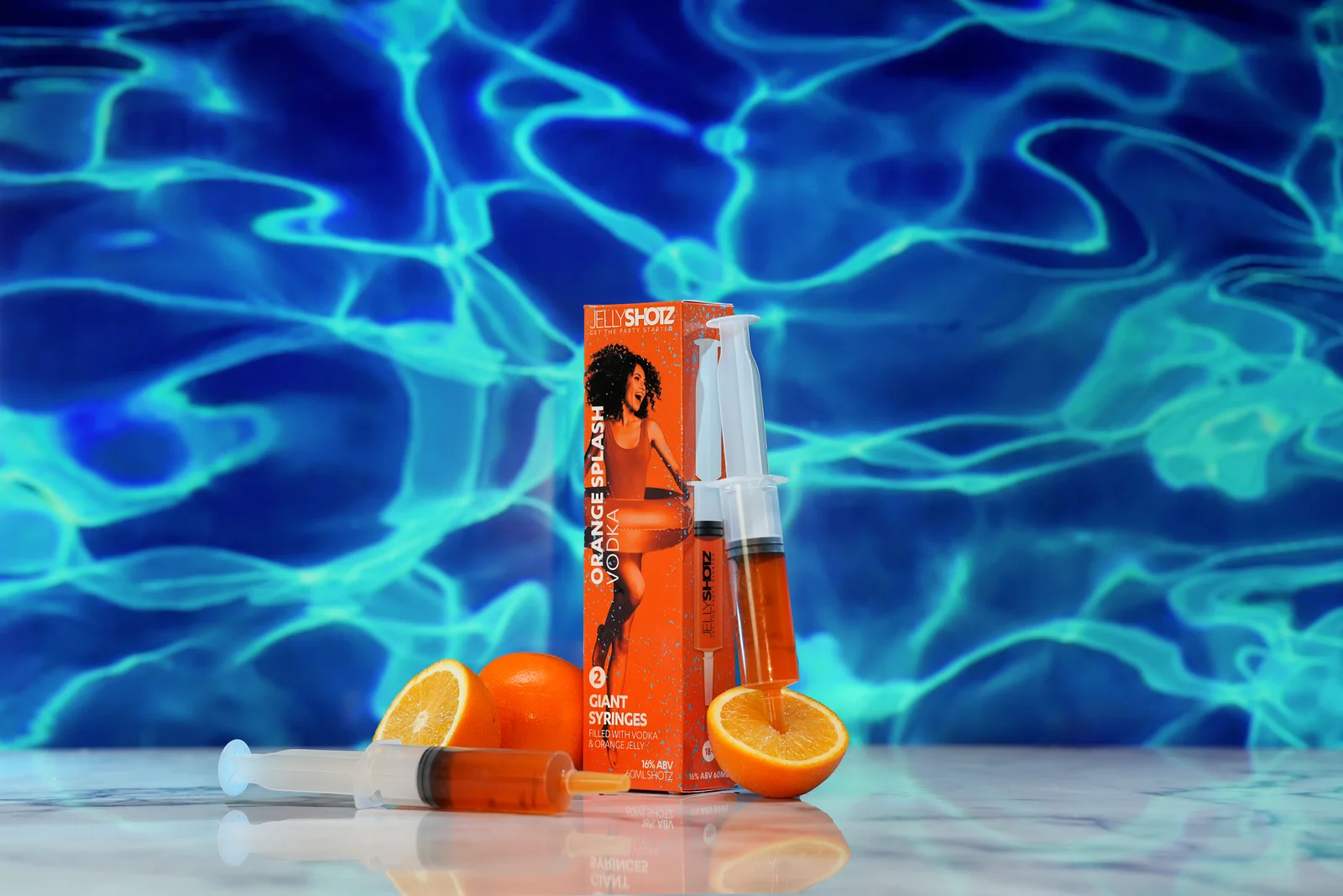 Jellyshotz Orange Splash Vodka — angled small pack against rippling blue water
