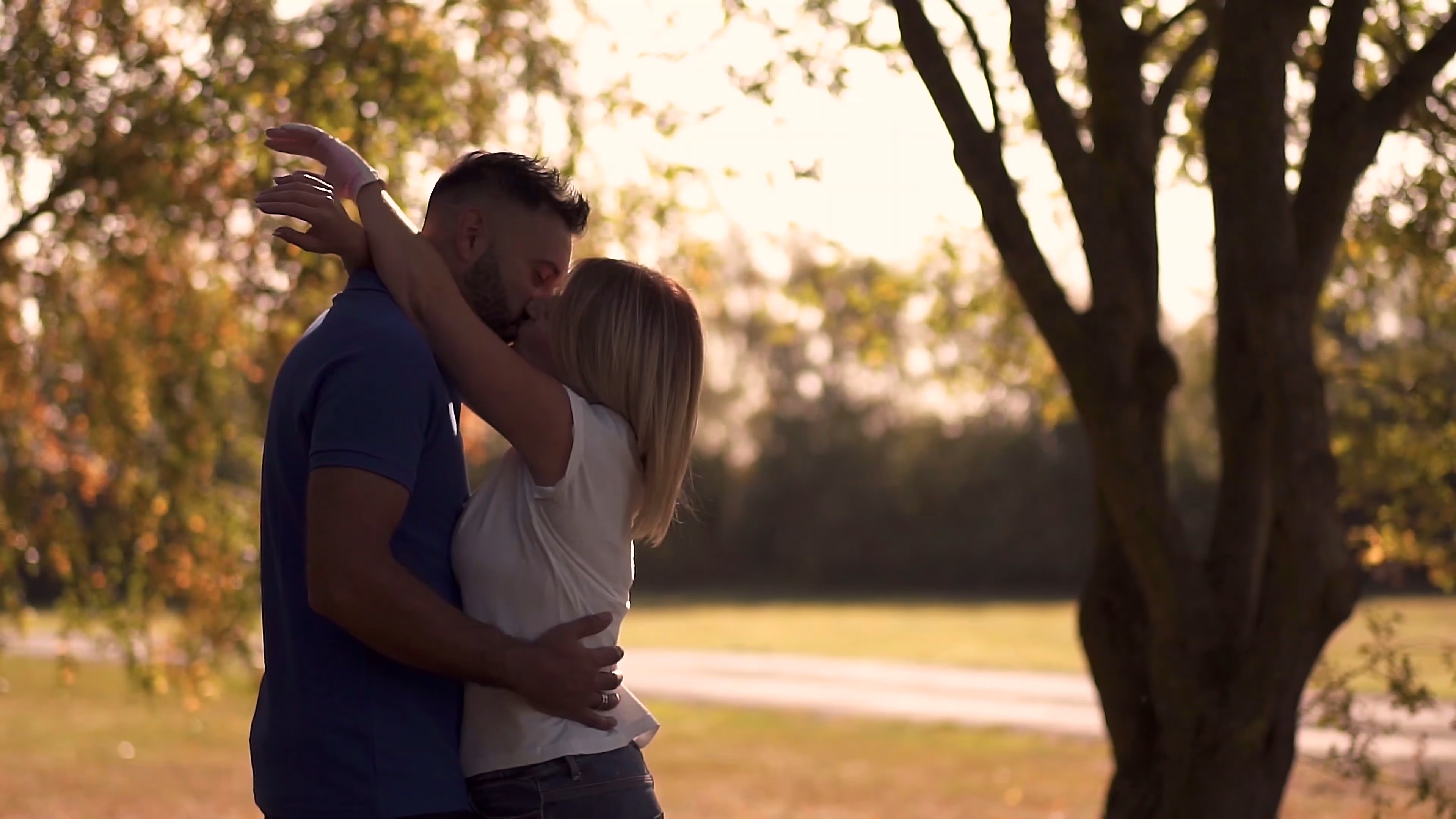 Jake and Lisa kissing beneath the autumn trees
