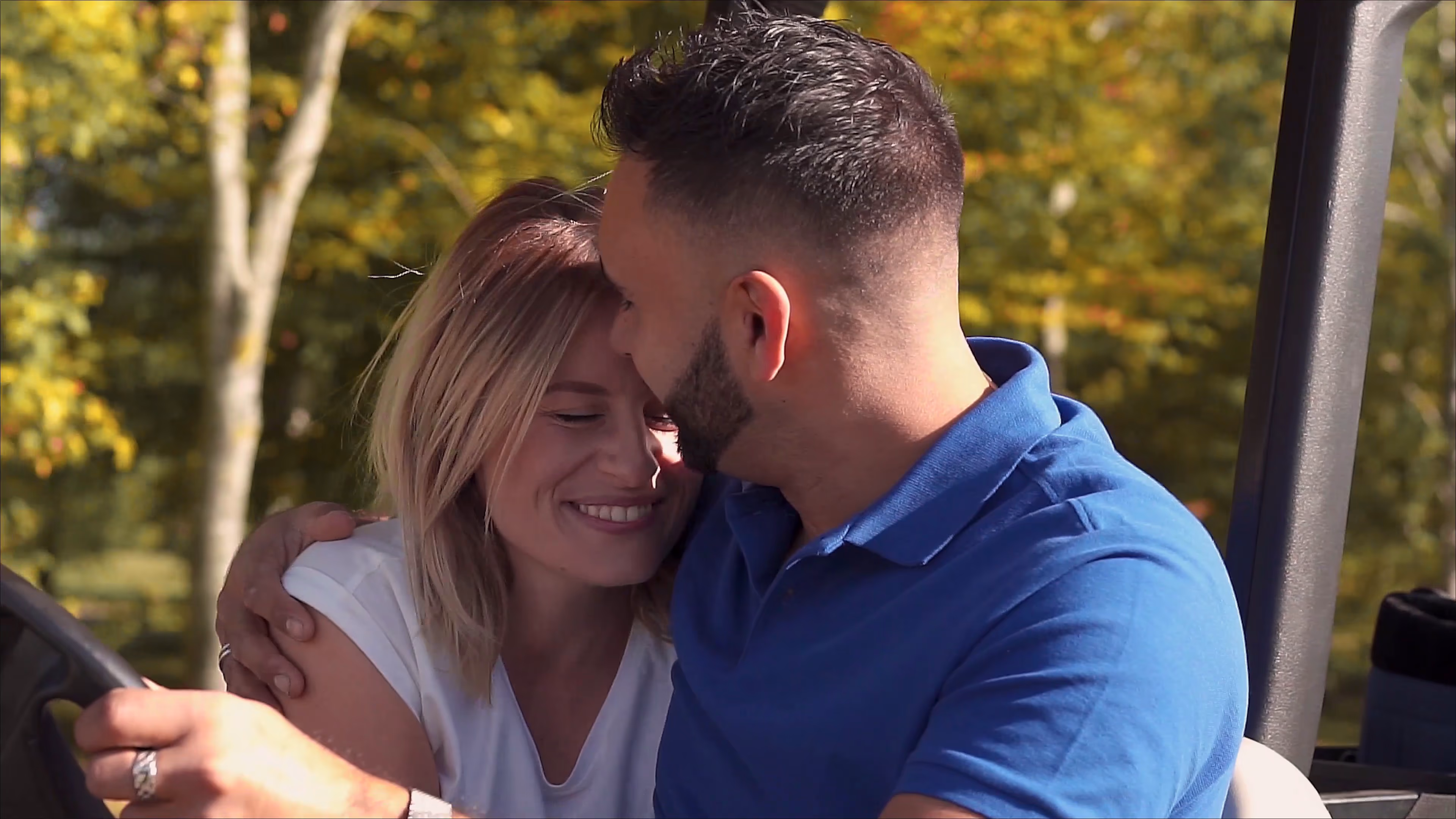 Jake and Lisa smiling together among autumn trees