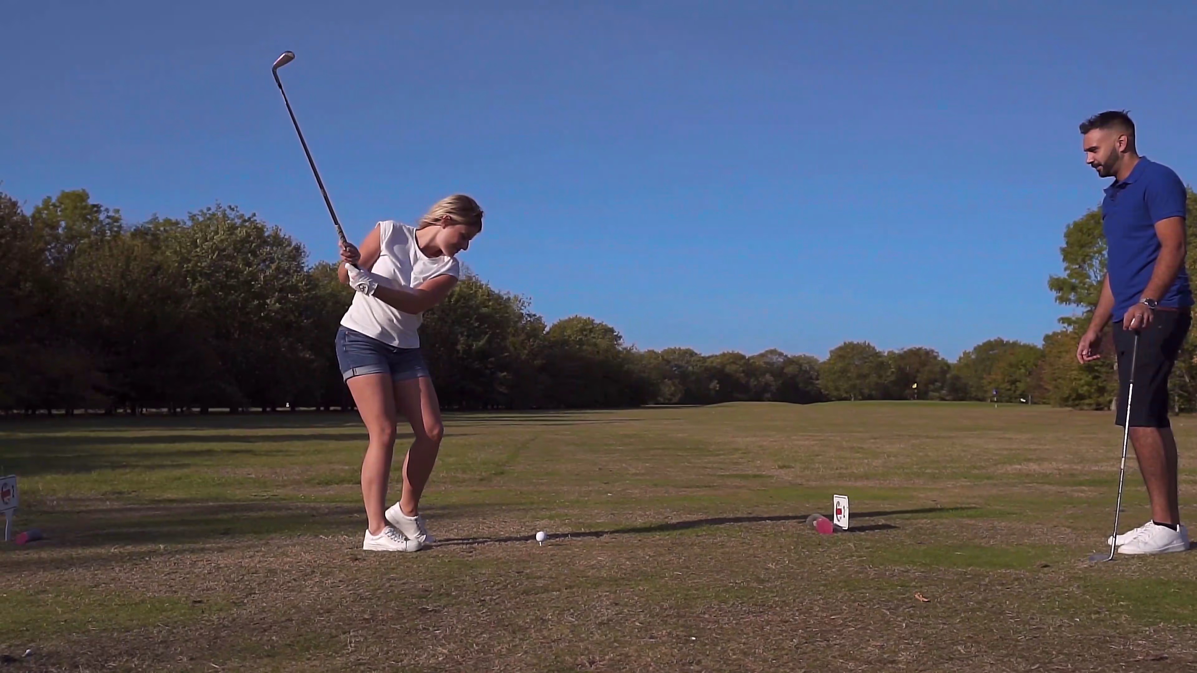 Lisa taking a golf shot during the first-date sequence