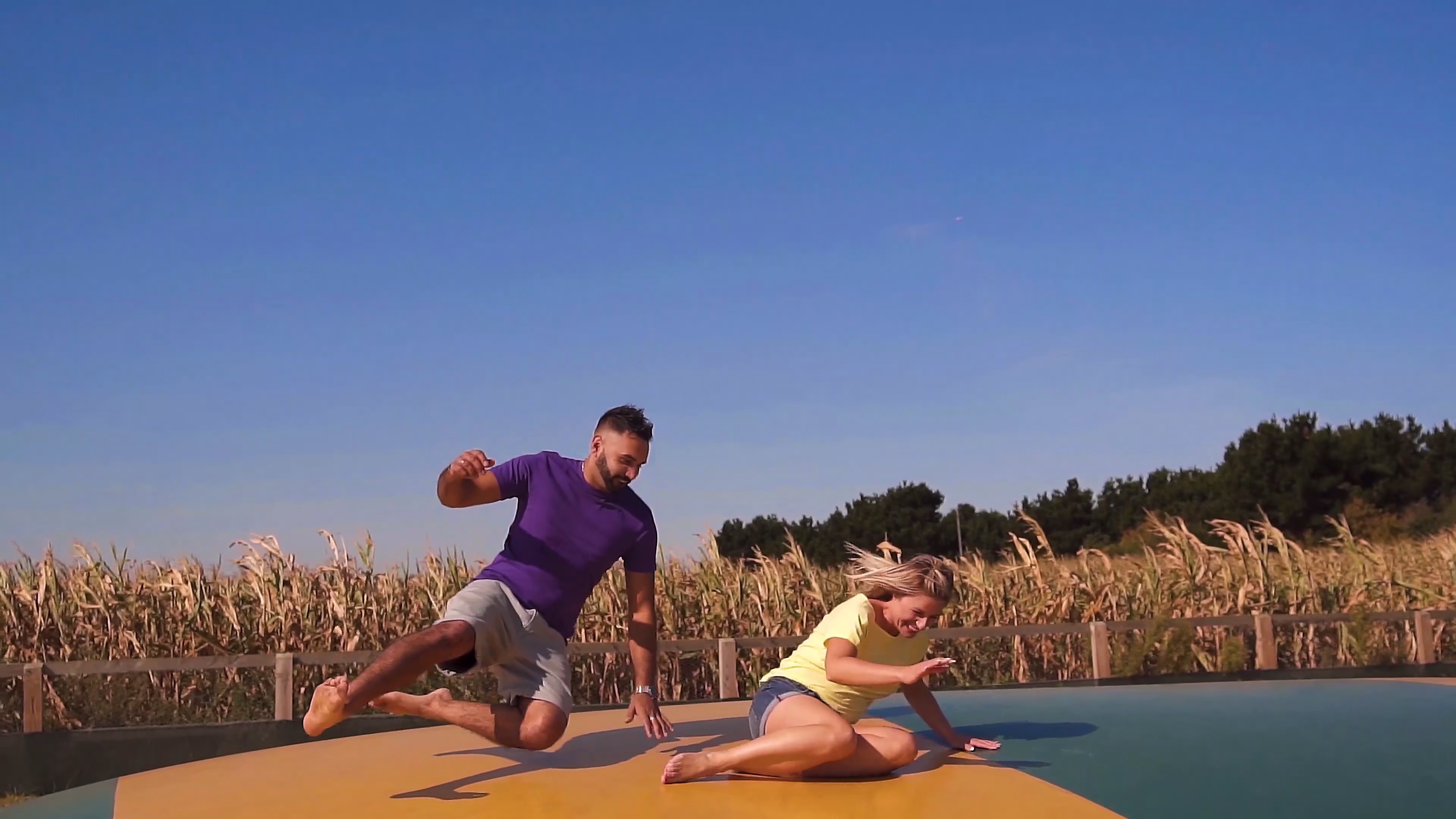 Jake and Lisa falling together on the giant jumping pillow