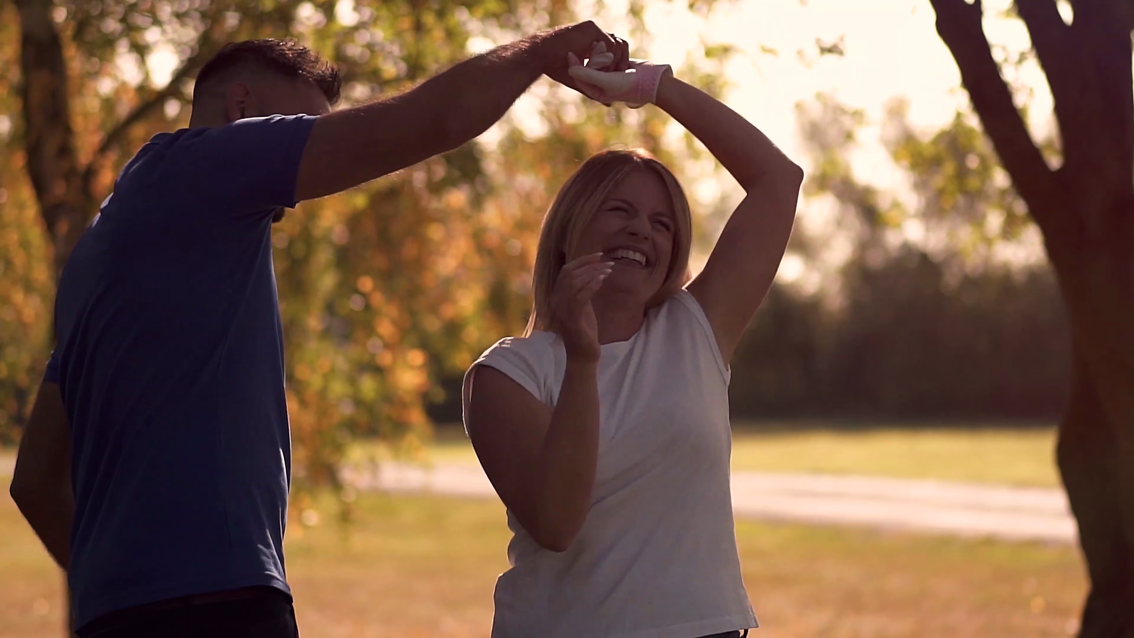Jake and Lisa dancing together during an autumn park date
