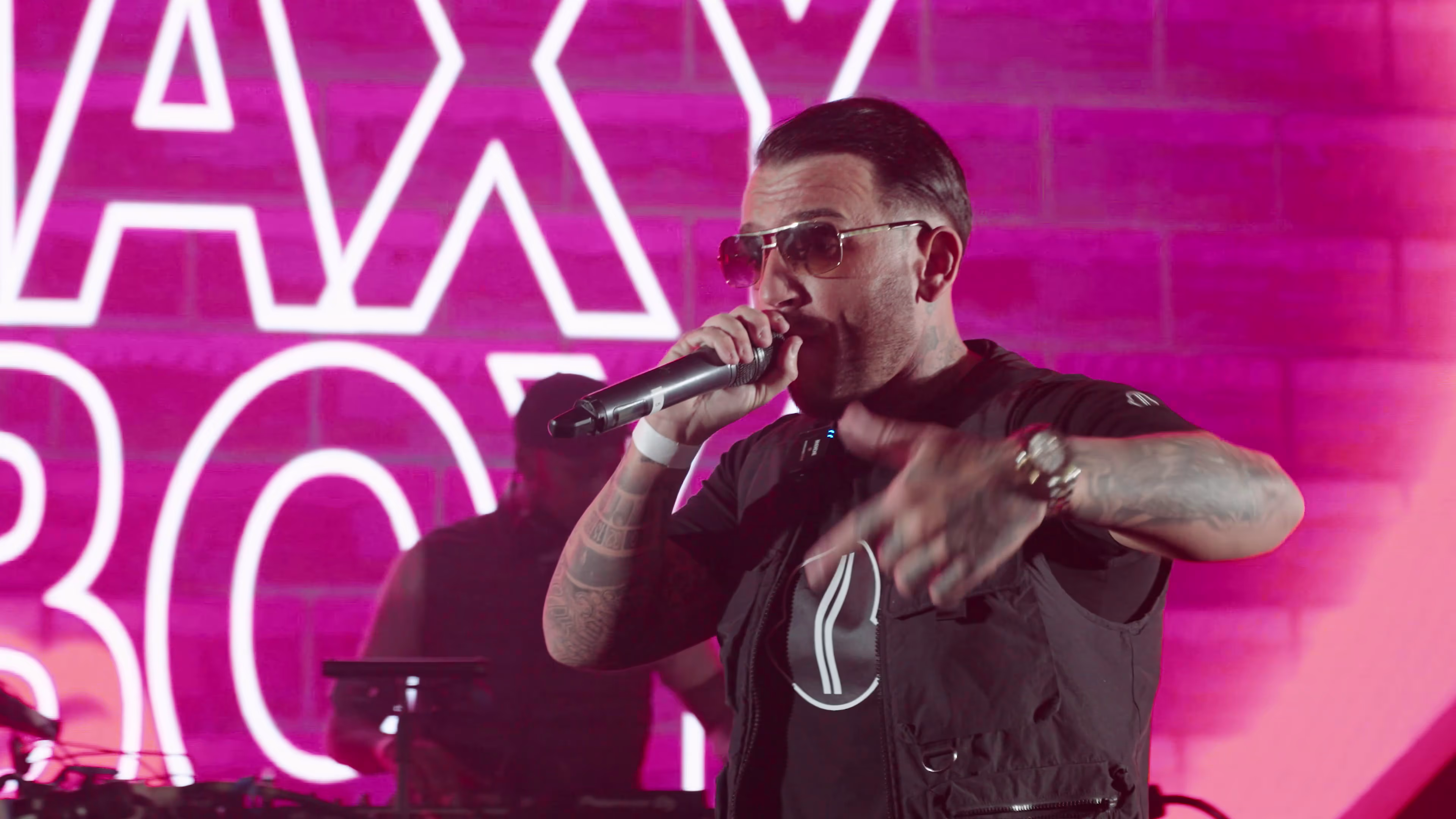 Maxy Boy performing under vivid pink event lighting in Basildon