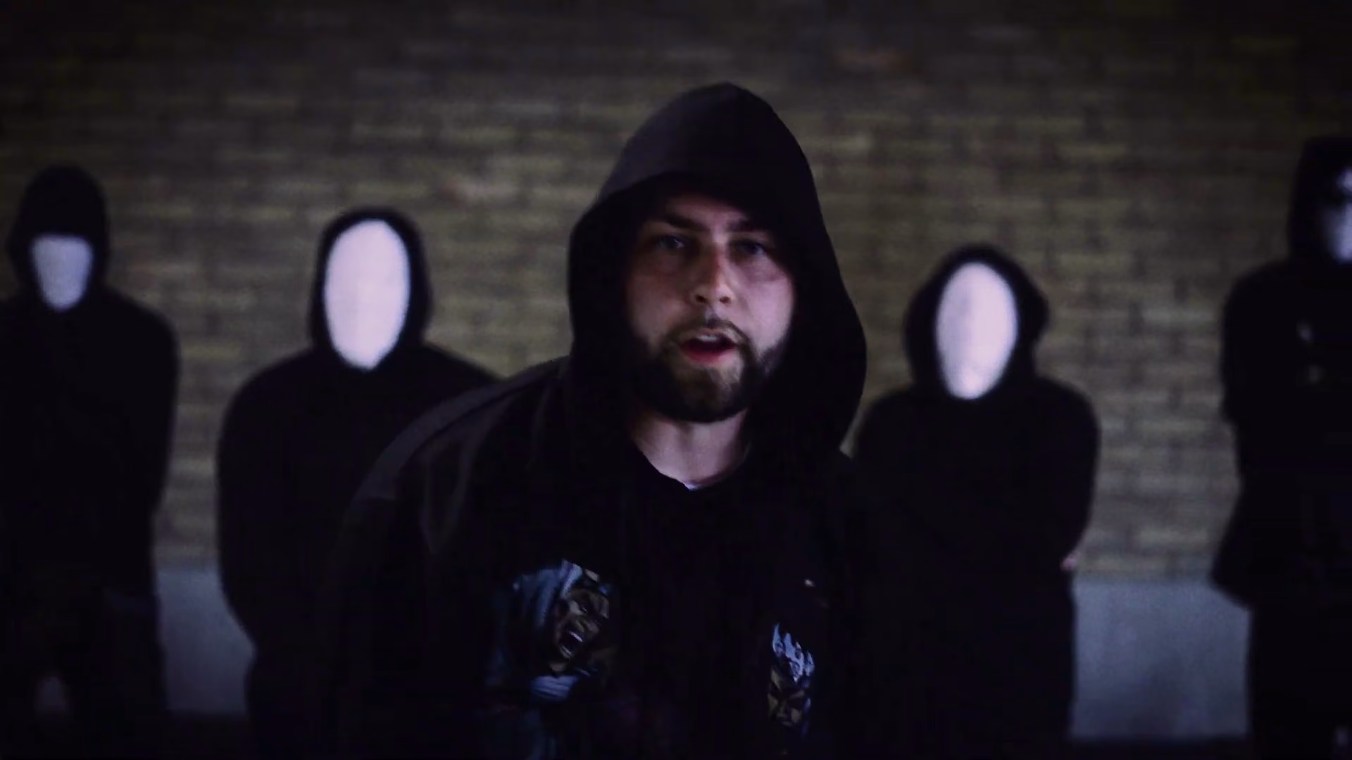 New Guardz rapper performing in front of masked figures in Swarmer
