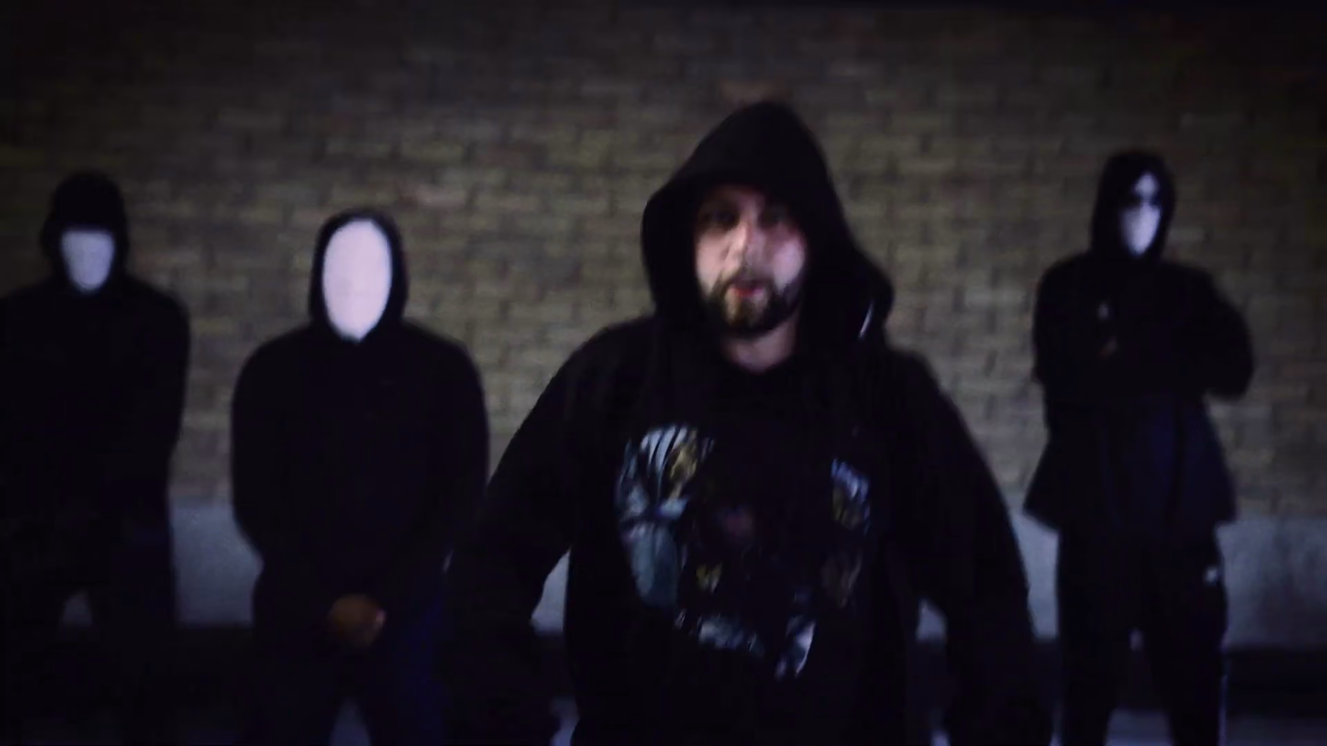 Hooded Swarmer performance setup with anonymous background figures