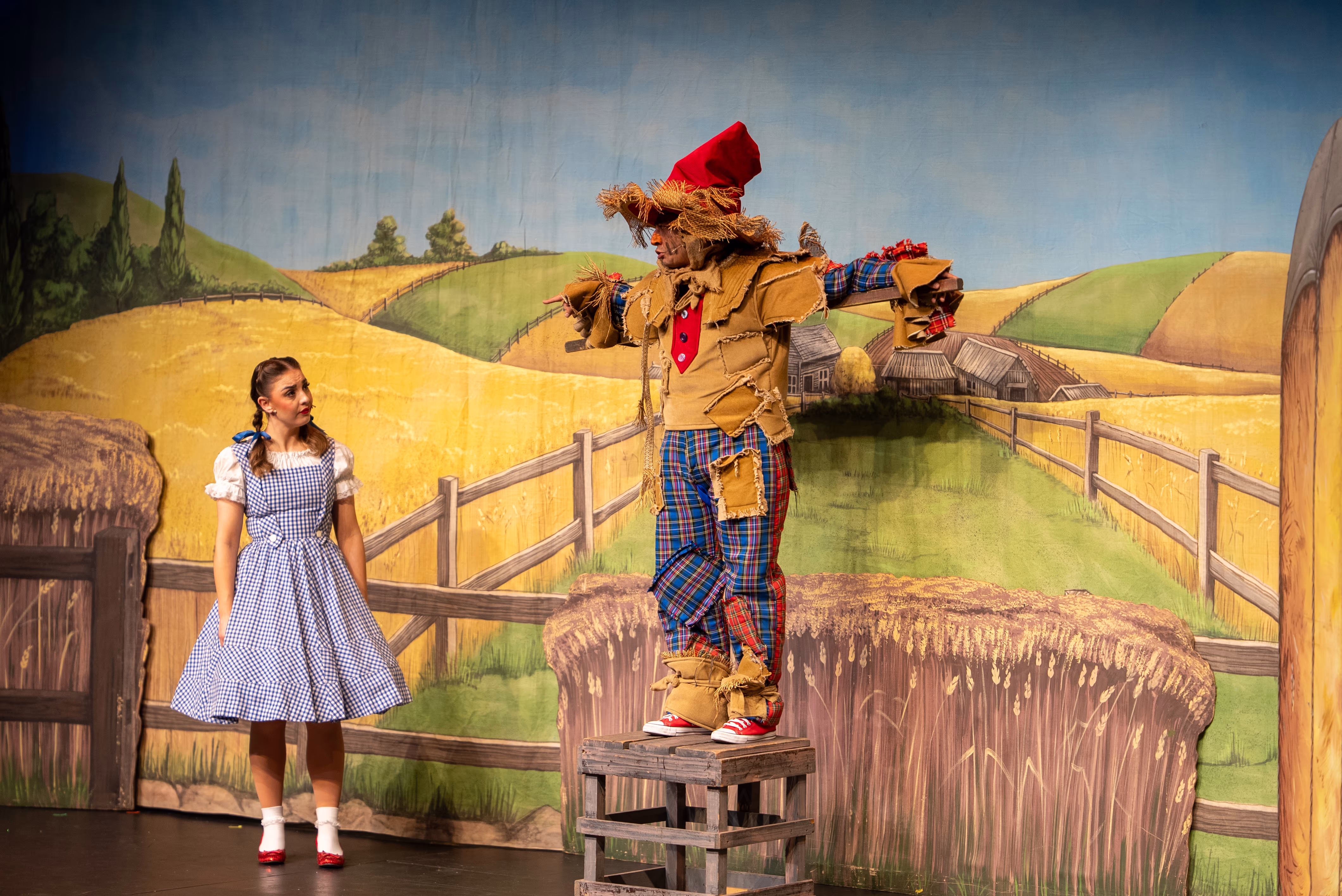 Dorothy and the Scarecrow in a wide stage scene from The Wizard of Oz