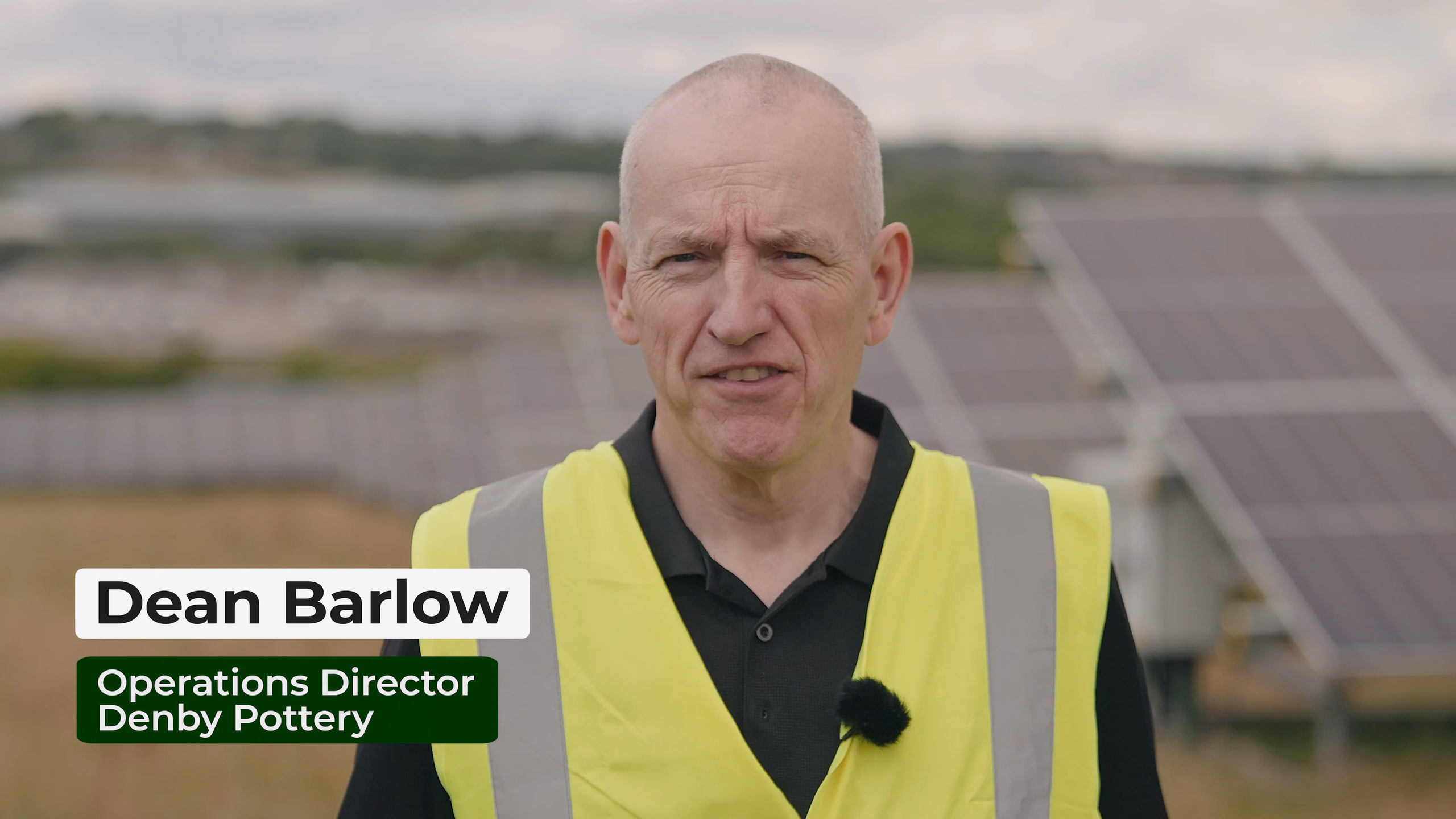 Dean Barlow speaking beside the solar array