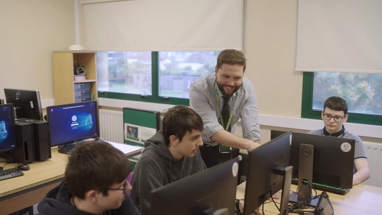 A teacher and students working together in a King Edmund School computer classroom