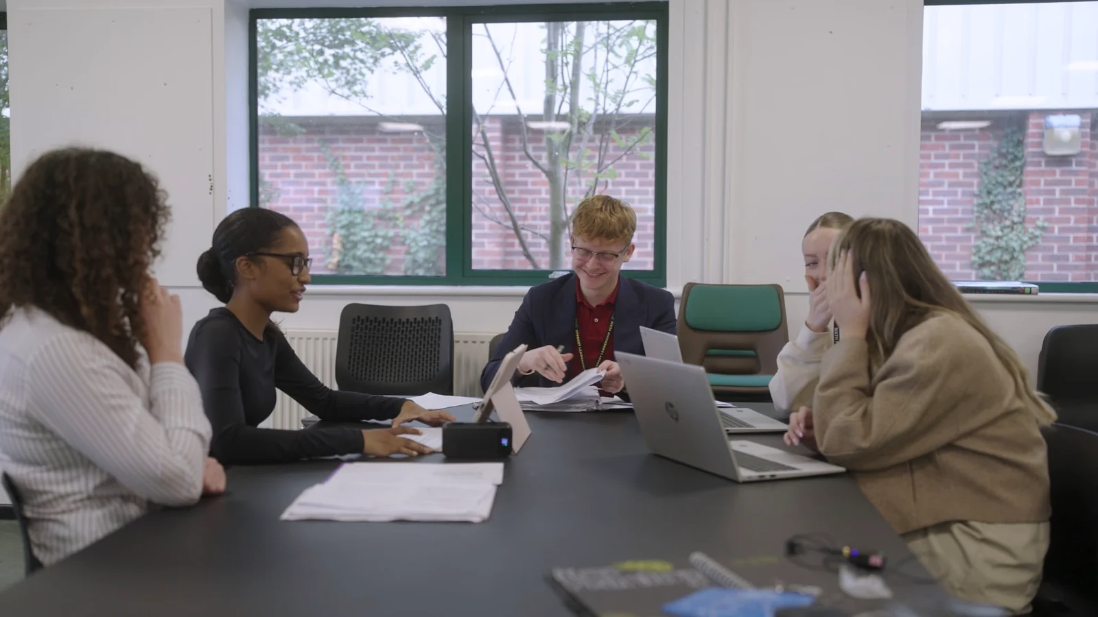 KES sixth-form students discussing work around a classroom table